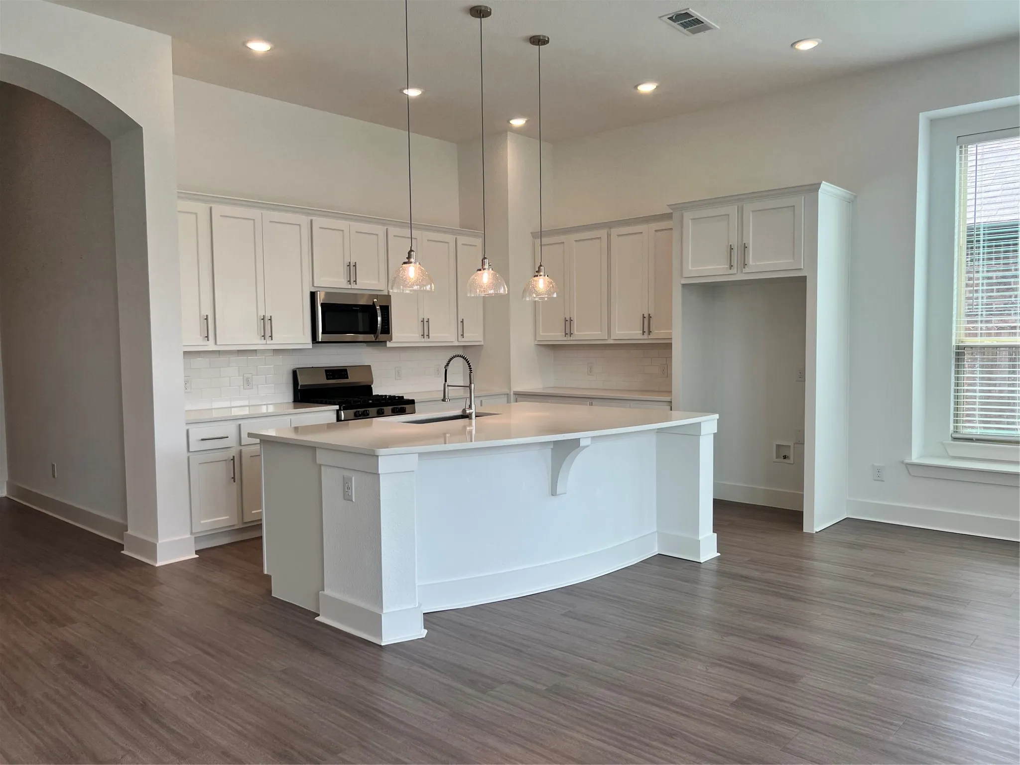 Beautiful kitchen with an abundance of cabinets, drawers and countertop space. Well lit with lighting and natural light coming through.