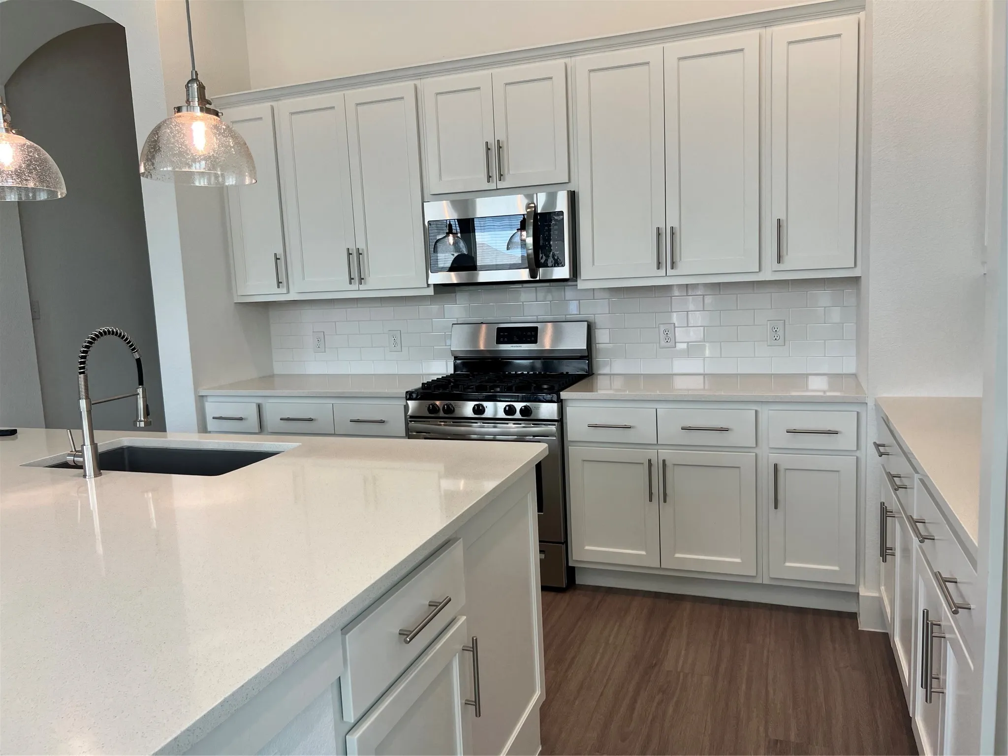 Gas range, quartz counters and plenty of cabinets and drawers.