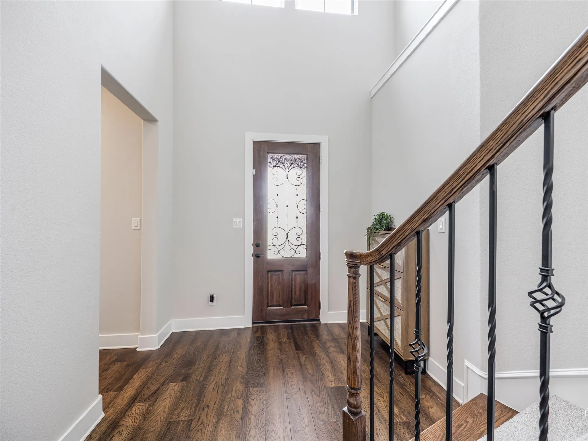  Elegant staircase at 544 Majors Road with rich wood floors and wrought-iron balusters, ascending to the upstairs loft, two bedrooms, and a full bathroom in this 4-bedroom, 3.5-bath Van Alstyne estate with soaring two-story ceilings.