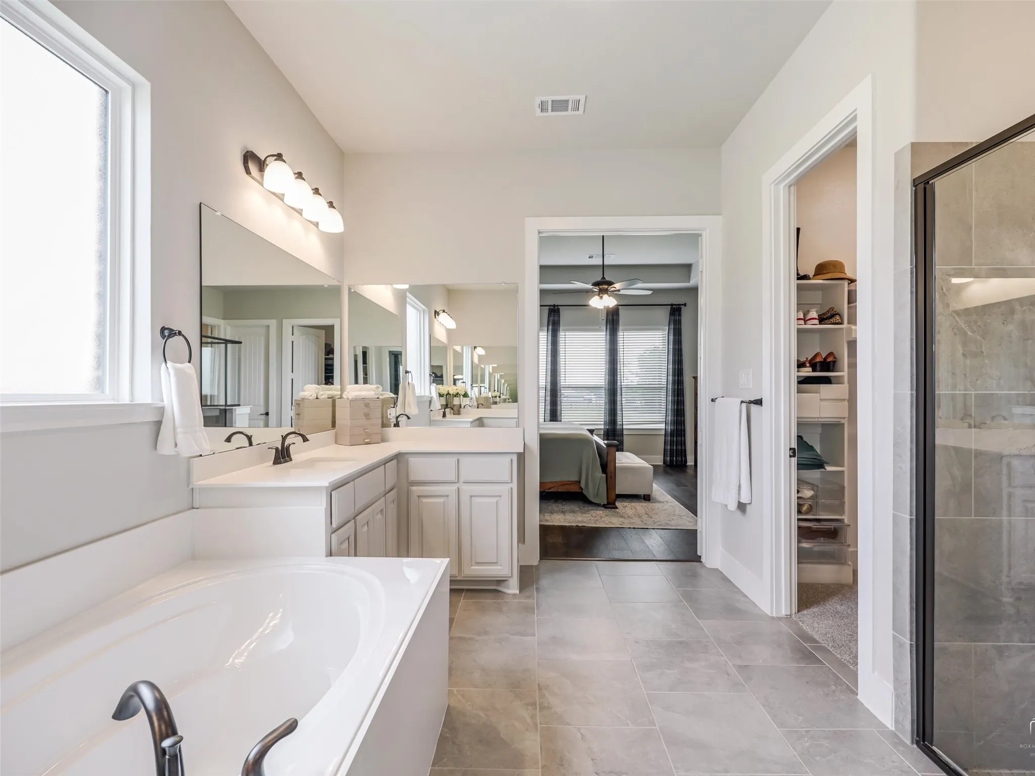 Dual vanities in the primary bathroom at 544 Majors Road, complementing the soaking tub, separate shower with built-in seat, and his-and-her walk-in closets.