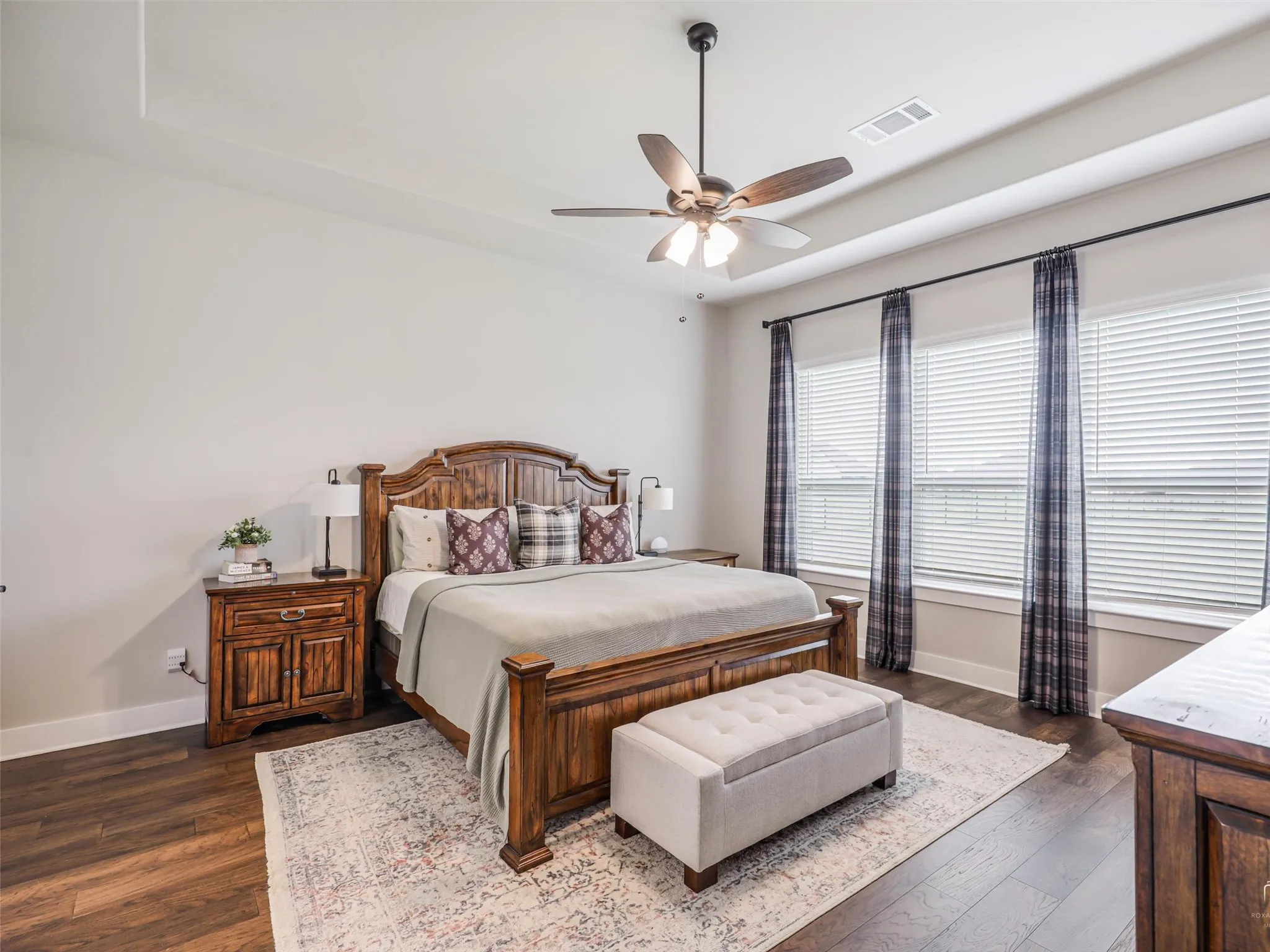Elegant primary suite at 544 Majors Road overlooking the 1-acre pipe-fenced backyard, featuring tray ceilings, wood floors, and his-and-her closets in Van Alstyne, Texas.
