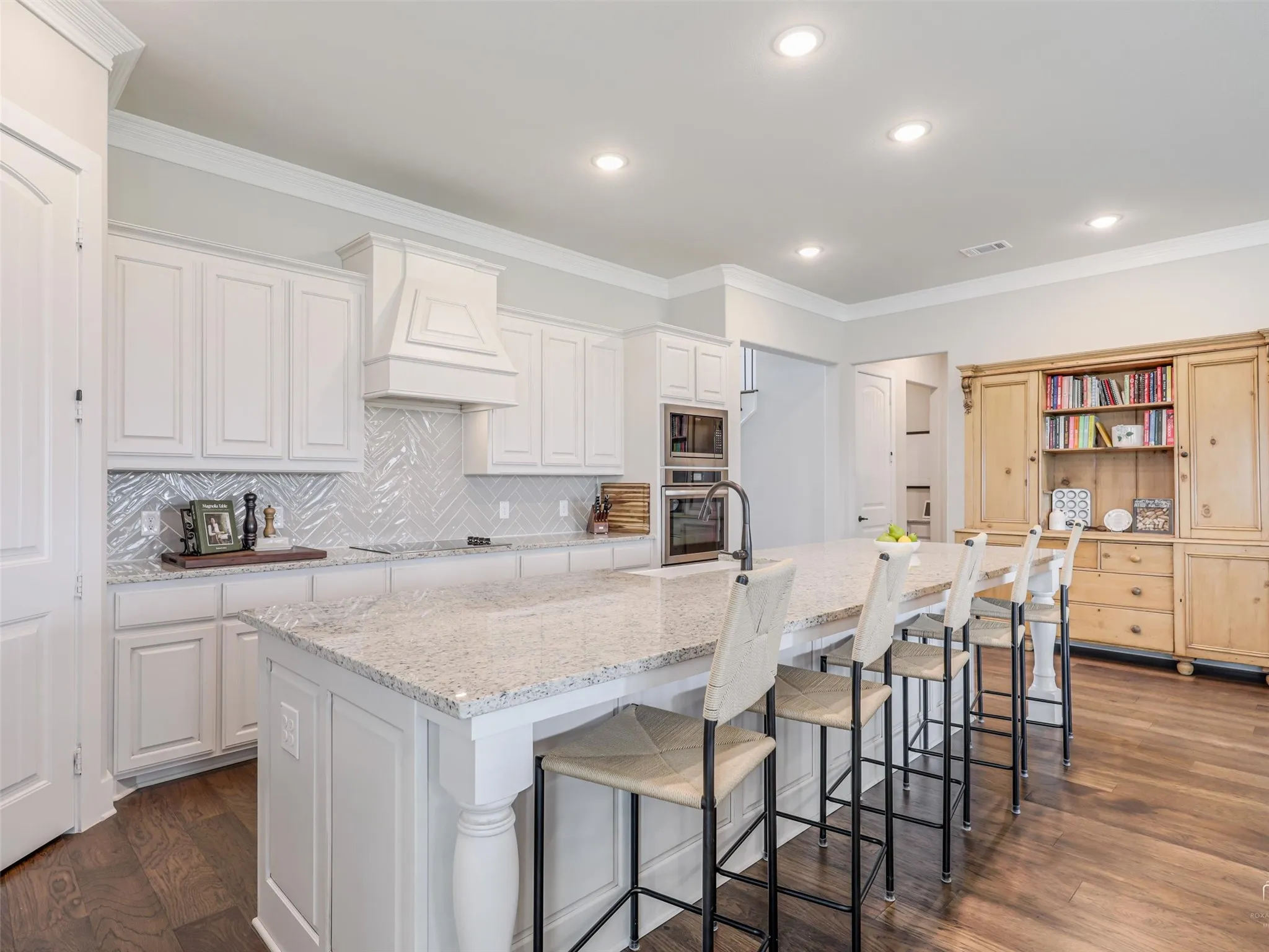 Elegant quartz countertops paired with abundant cabinetry at 544 Majors Road, Van Alstyne, TX, in a chef's kitchen also featuring double ovens and a farmhouse apron sink.