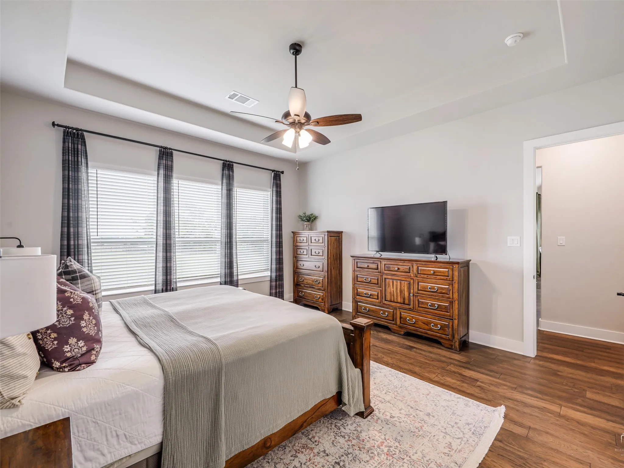 Third perspective of the primary suite at 544 Majors Road, highlighting the abundant natural light, wood floors, and peaceful backyard views of this 4-bedroom, 3.5-bath Van Alstyne estate on 1 acre.