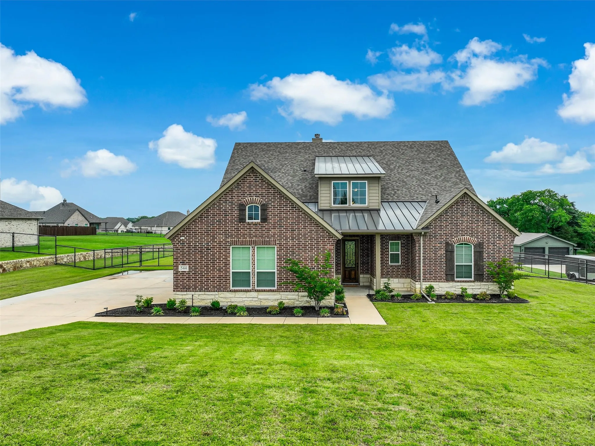 Architectural front elevation detail of 544 Majors Road highlighting the grand two-story façade, covered entry, and mature landscaping at this 4-bedroom, 3.5-bath Van Alstyne estate on 1 acre.
