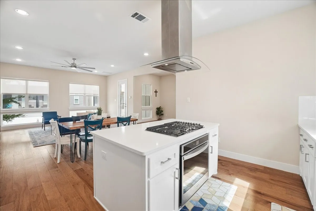 Open-concept living space featuring wood-finish flooring, recessed lighting, and a contemporary ceiling fan