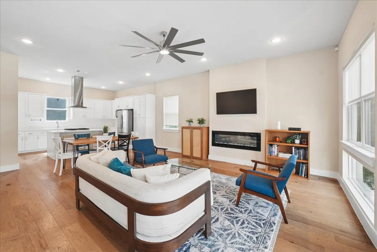 Open-concept living space featuring wood-finish flooring, recessed lighting, and a contemporary ceiling fan