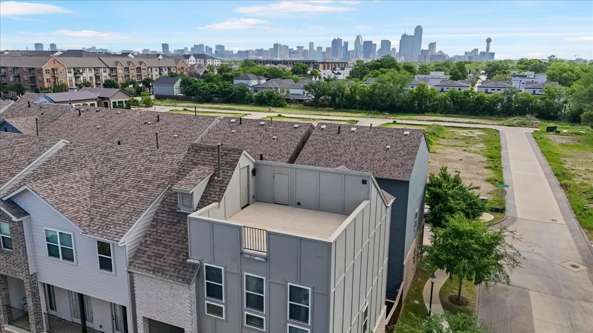 Rooftop terrace featuring metal railing and urban skyline in the background