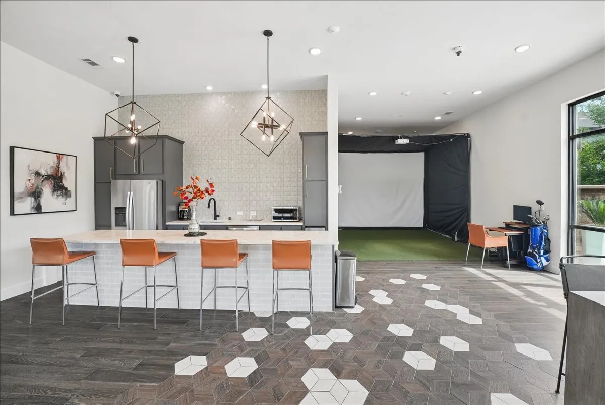 Modern kitchen area featuring a large island with seating, stainless steel appliances, and dark cabinetry