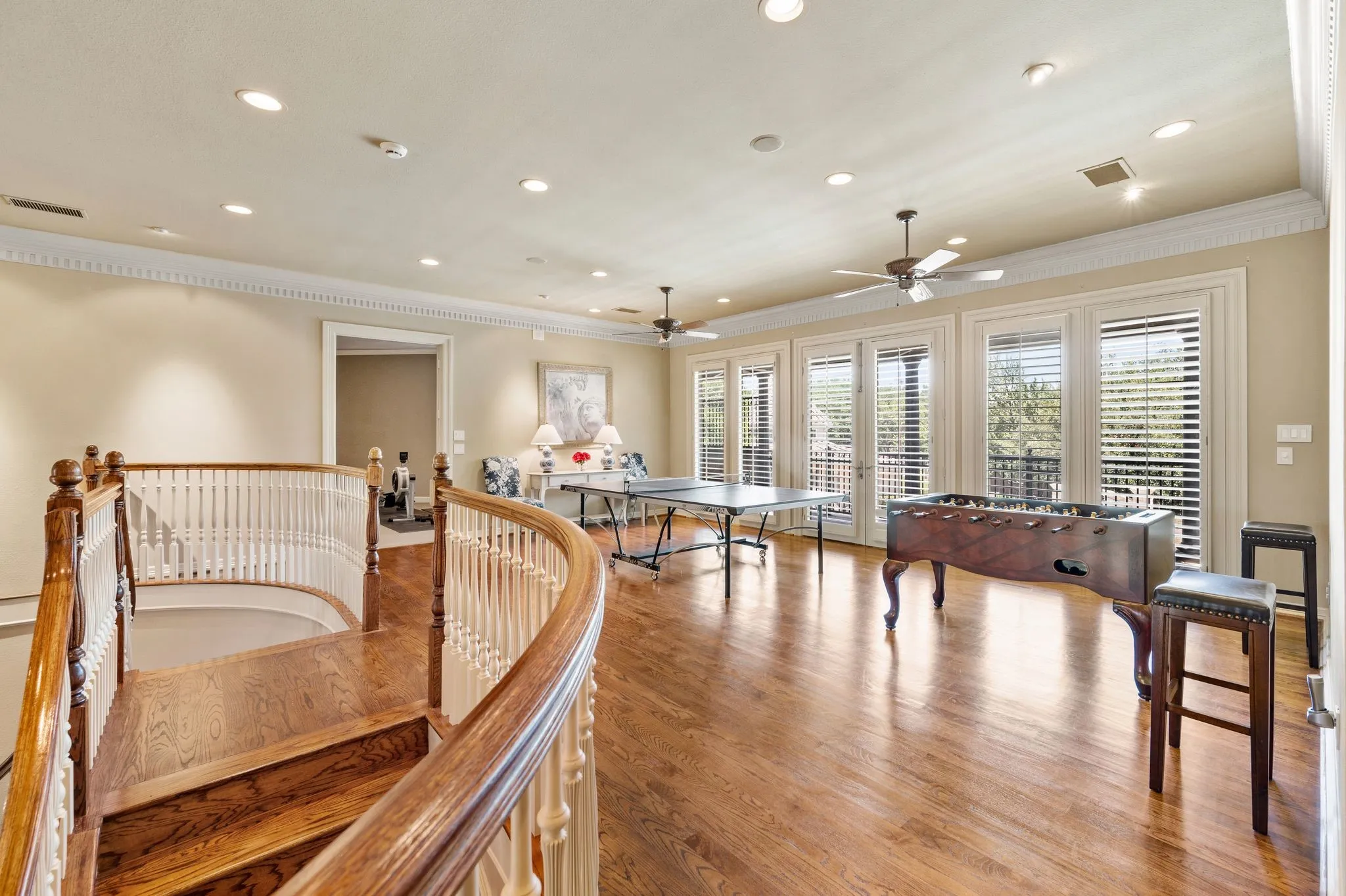 Upper-level space featuring a curved staircase with hardwood steps and white balusters