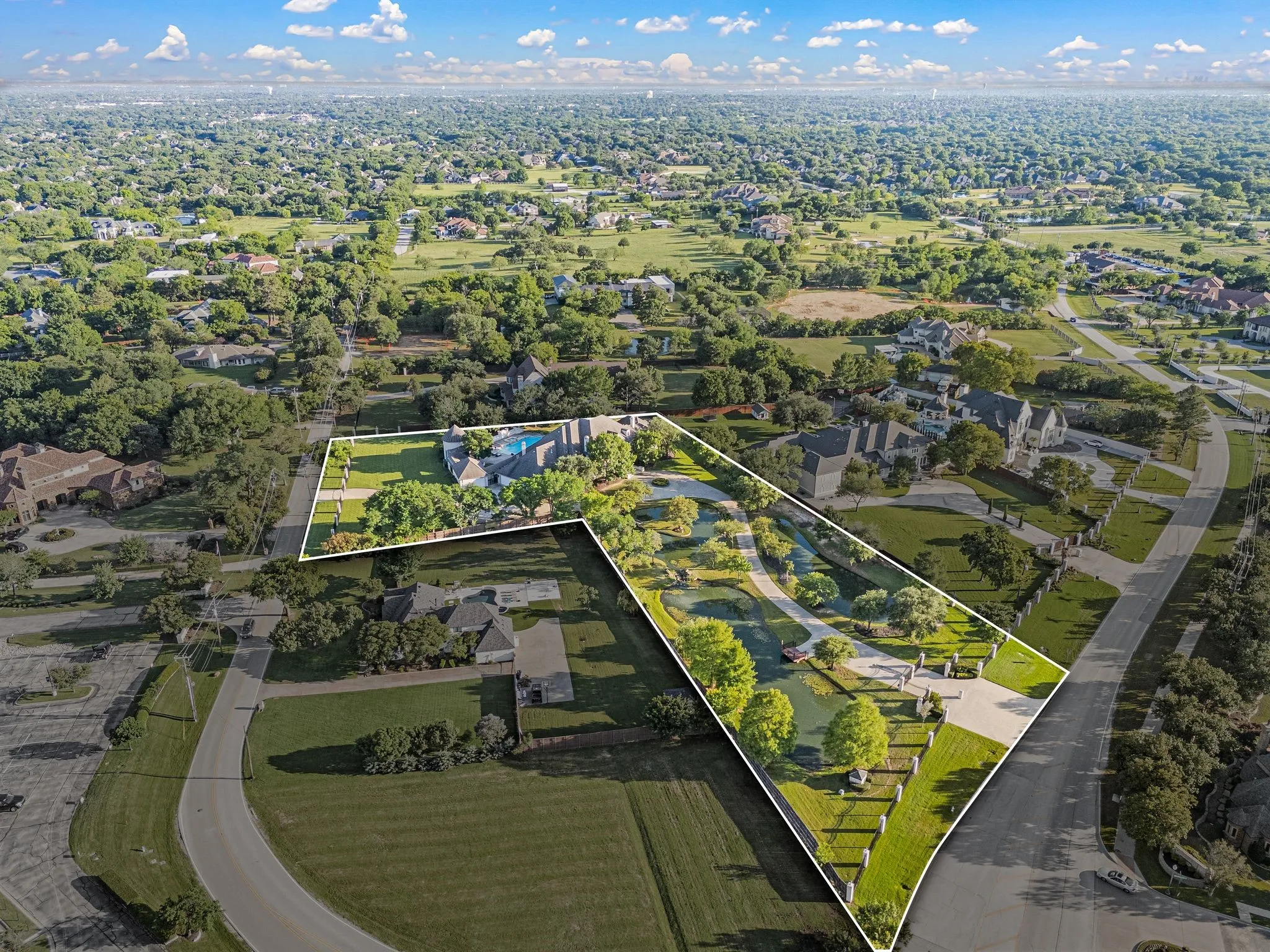 Expansive property with a large main residence, swimming pool, and extensive paved driveways