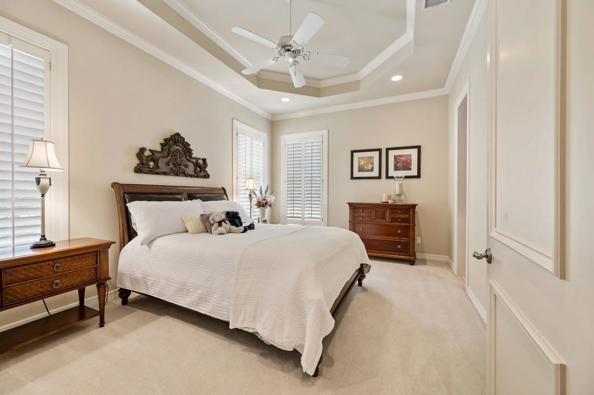 Carpeted bedroom with a tray ceiling and recessed lighting