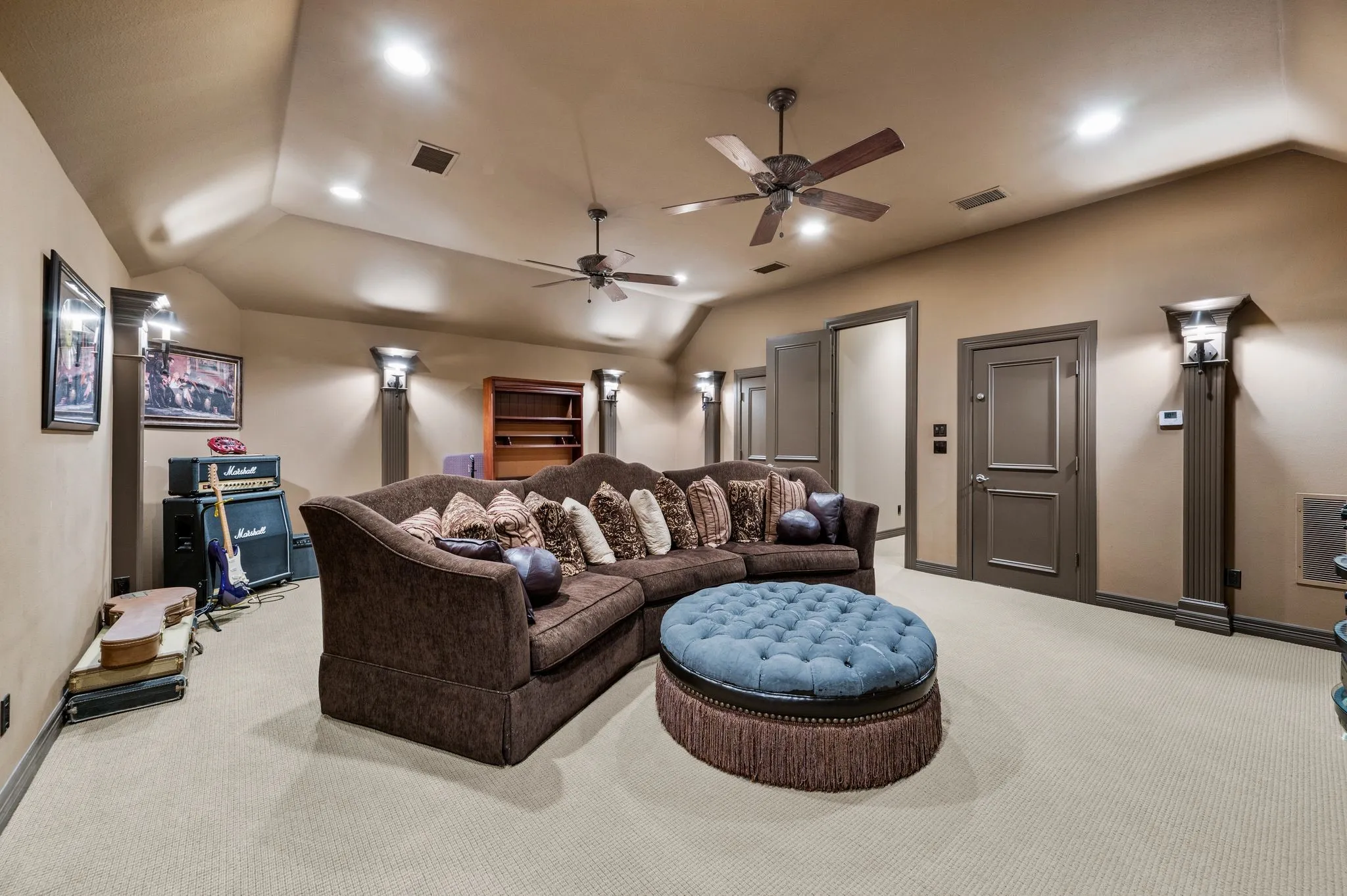 Carpeted room featuring a sloped ceiling with recessed lighting and two ceiling fans
