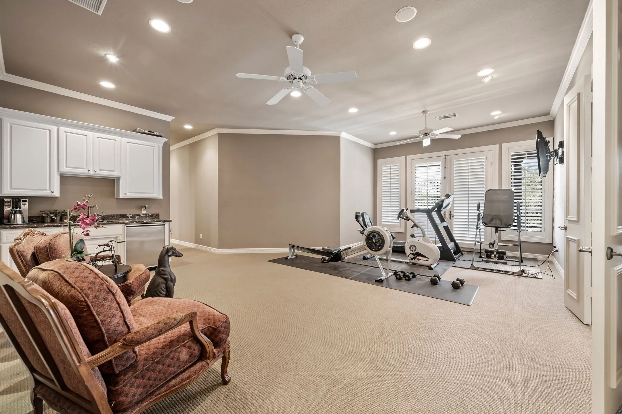 Spacious recreation room featuring recessed lighting, crown molding, and neutral-toned carpeting
