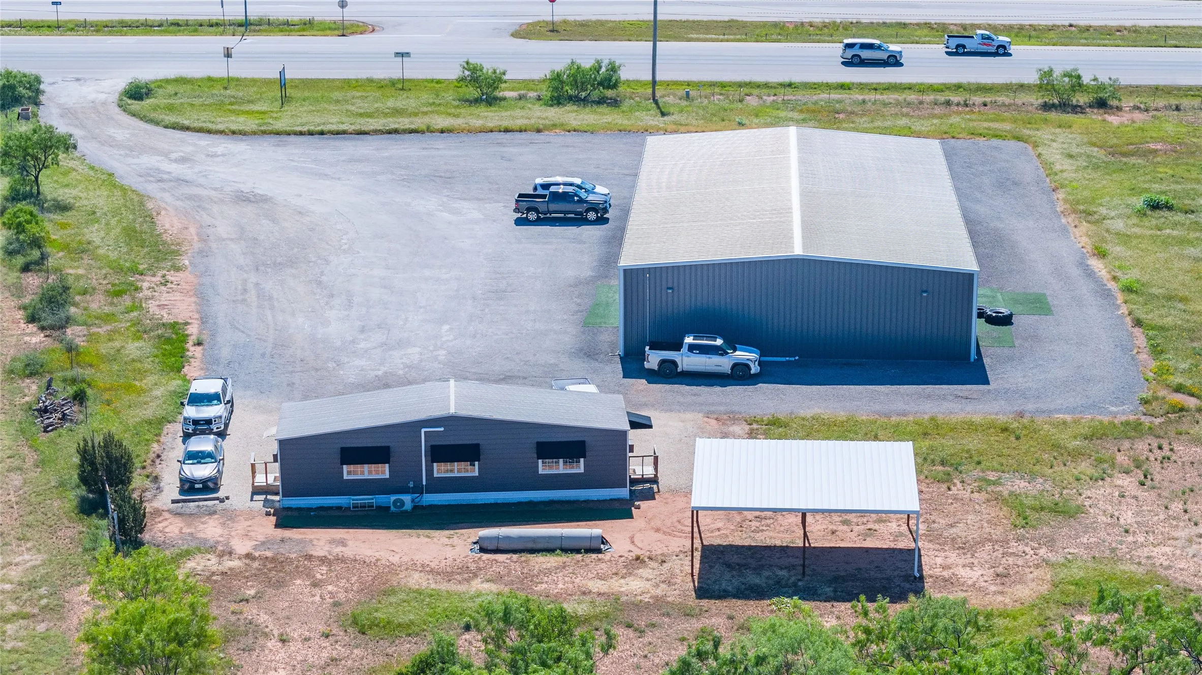 Property featuring a metal building, a modular structure, and a detached carport