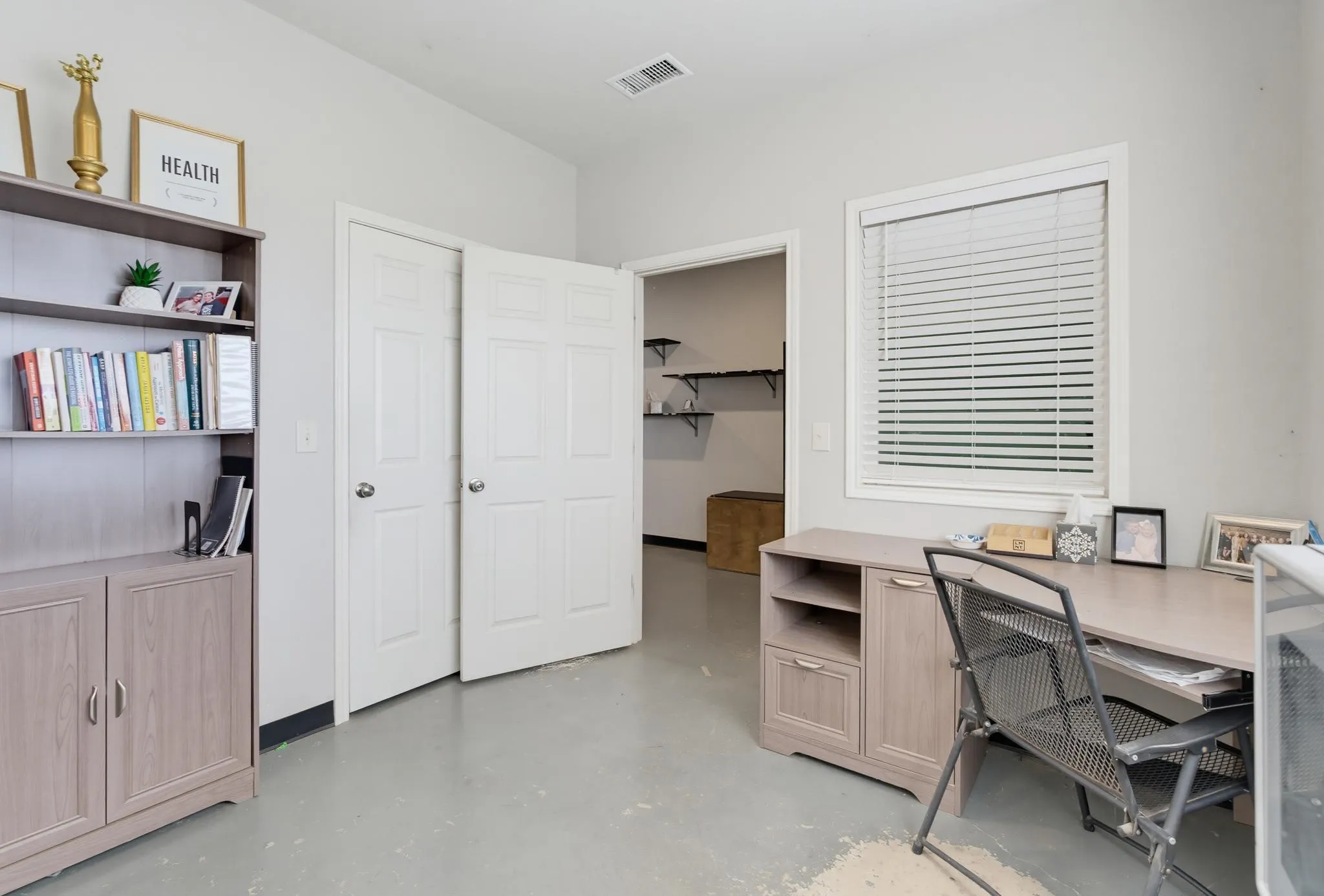 Built-in shelving, window with blinds, and white interior doors