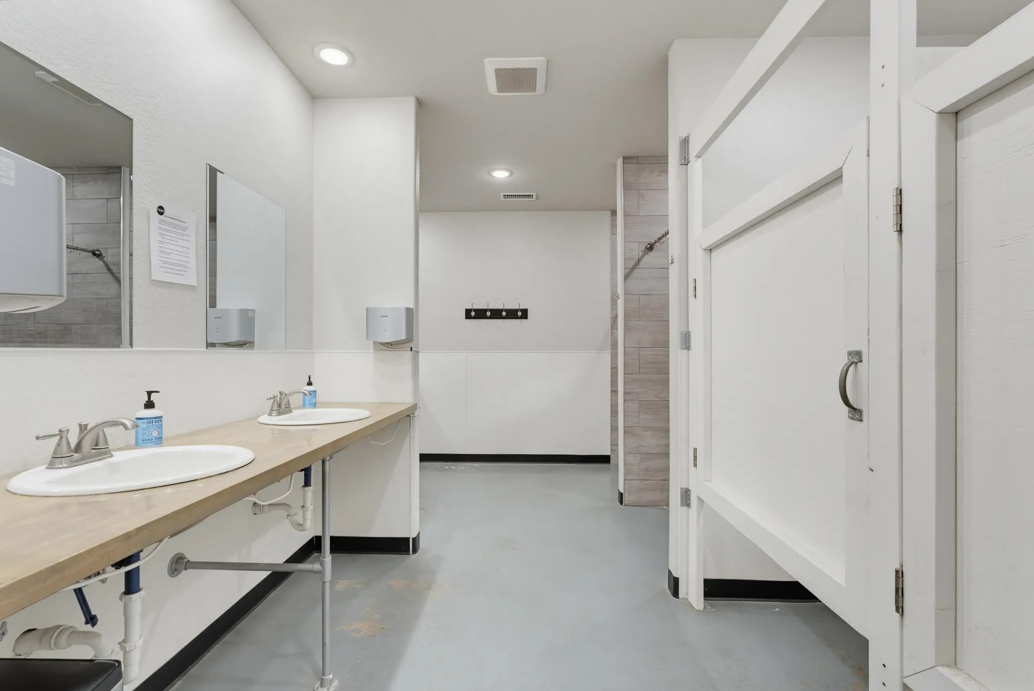 Dual undermount sinks with brushed nickel faucets, wood-finish countertop, and recessed lighting