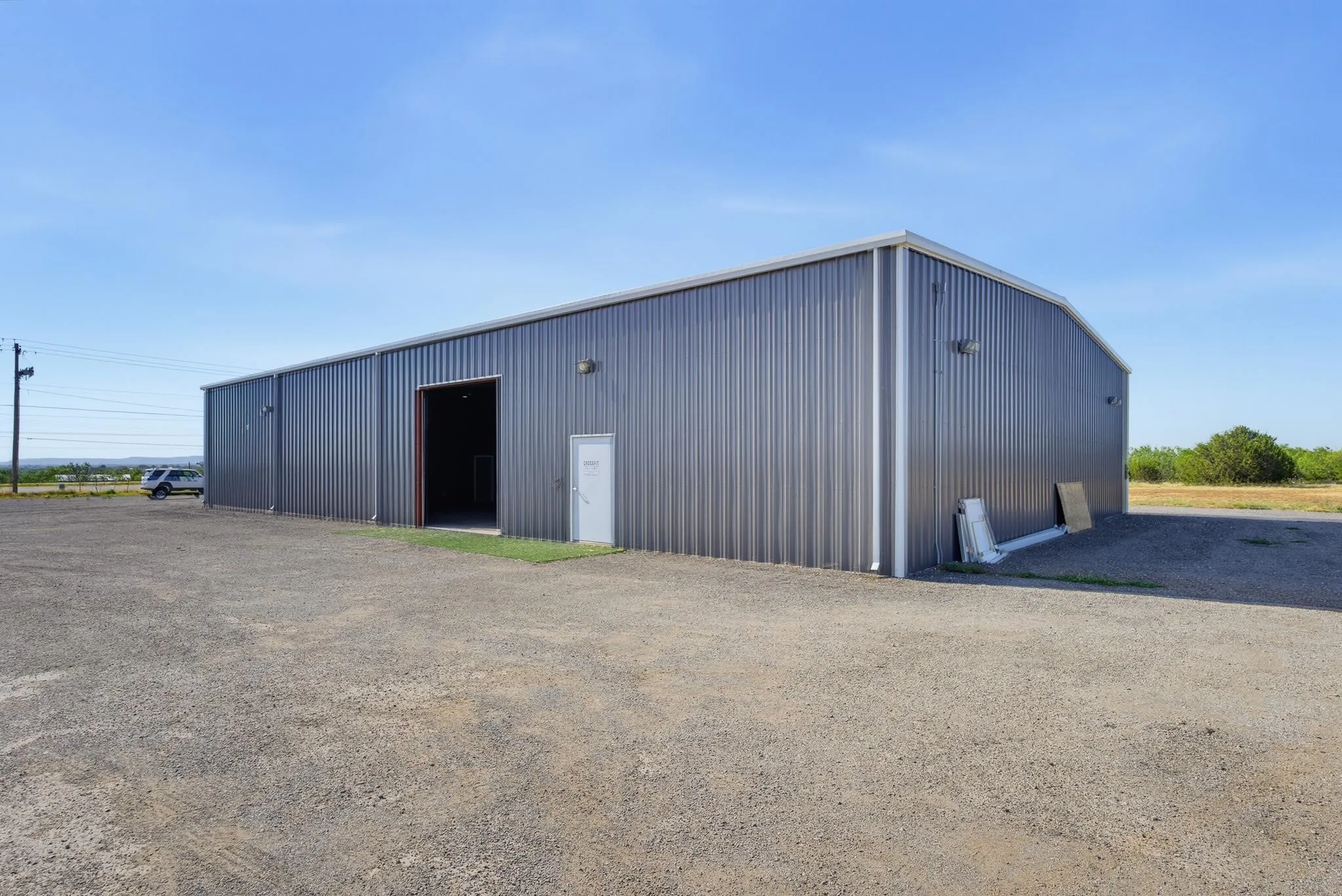 Metal-clad structure with a large overhead door and a pedestrian entrance