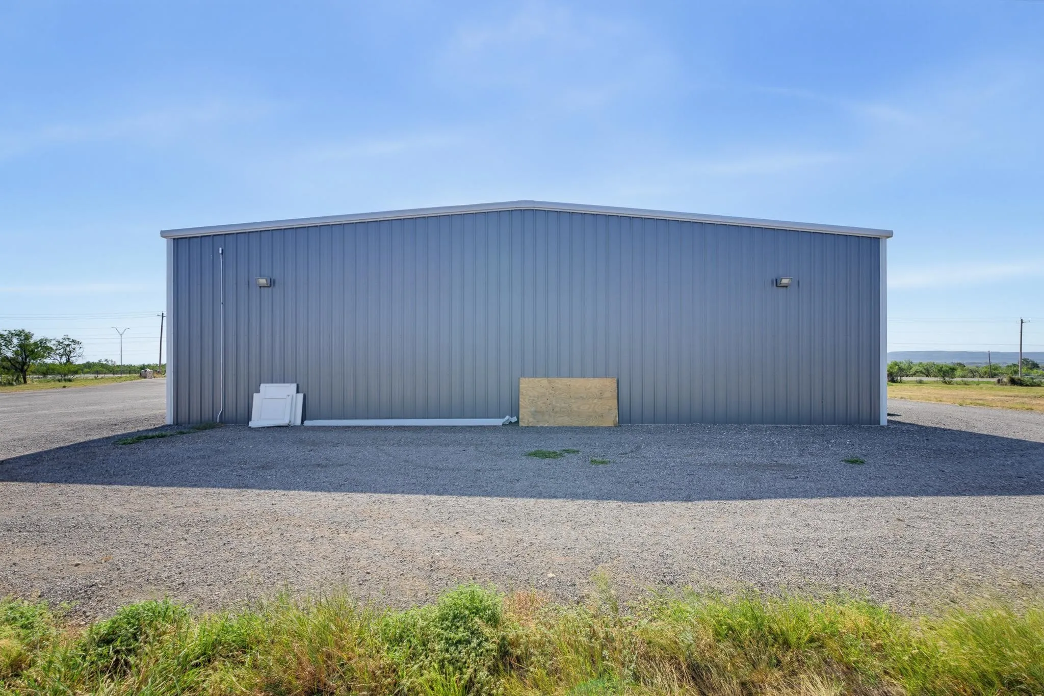 Metal-sided structure with a sloped roof and exterior lighting
