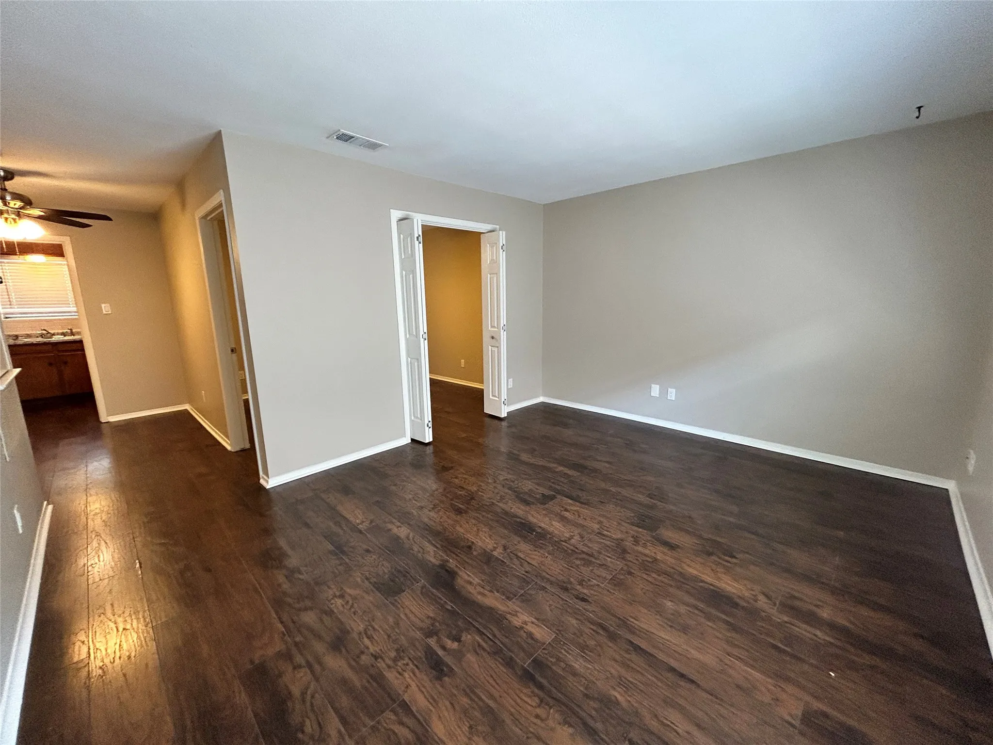 Wood-finish flooring throughout, neutral wall tones, and white trim