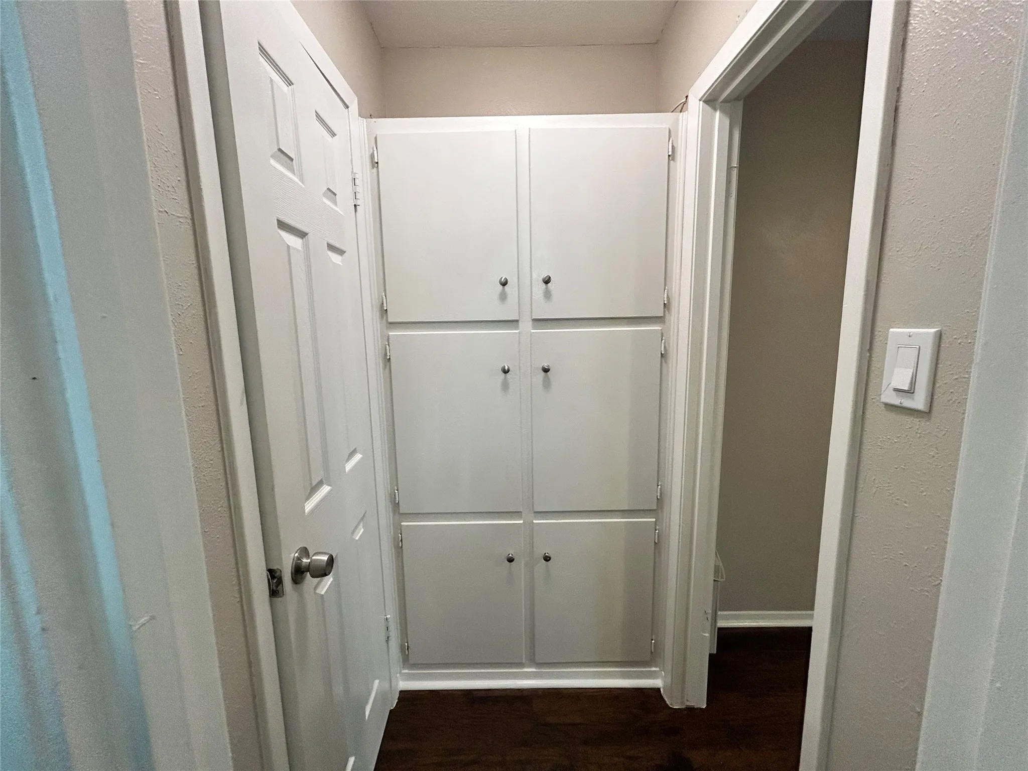 White built-in storage cabinetry with dark hardware