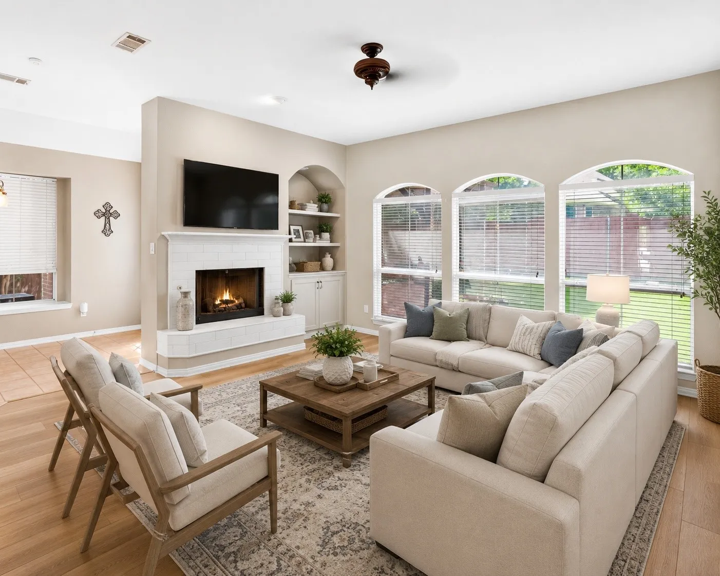 Living area featuring a tiled fireplace with mantel, built-in shelving, and multiple arched windows