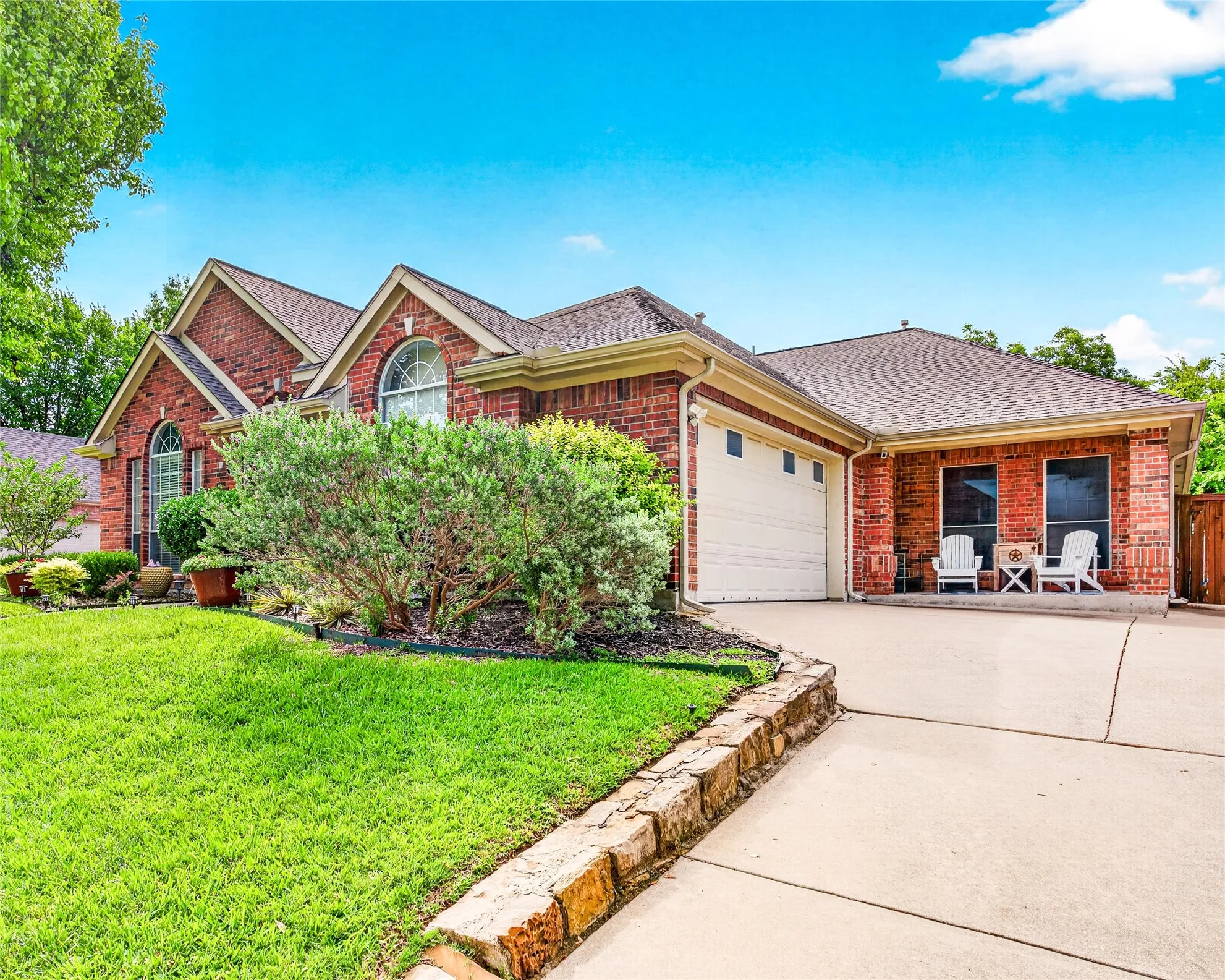 Brick exterior with a gabled roofline, arched windows, and an attached two-car garage