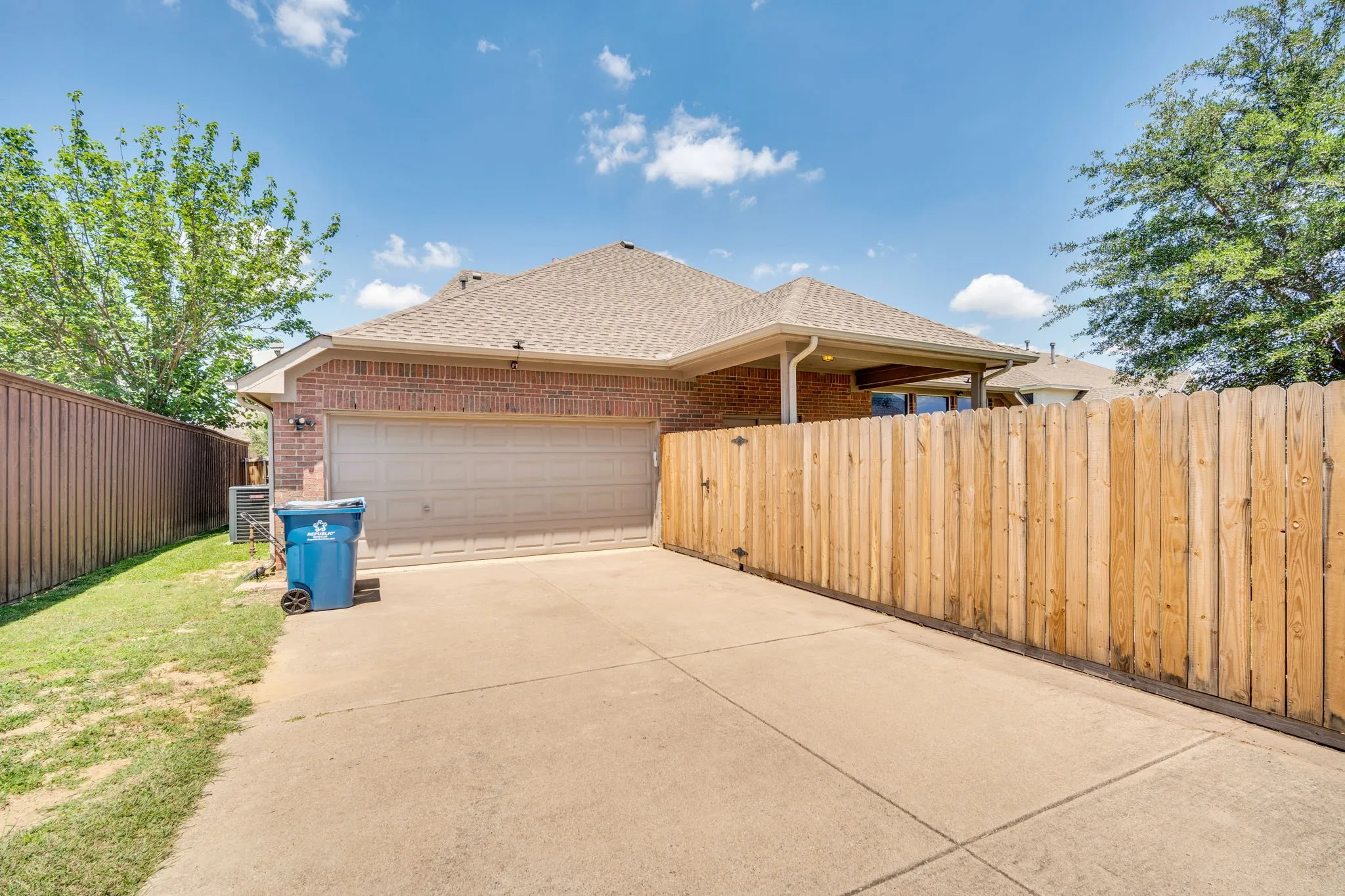 Brick exterior featuring a two-car garage with an automatic door