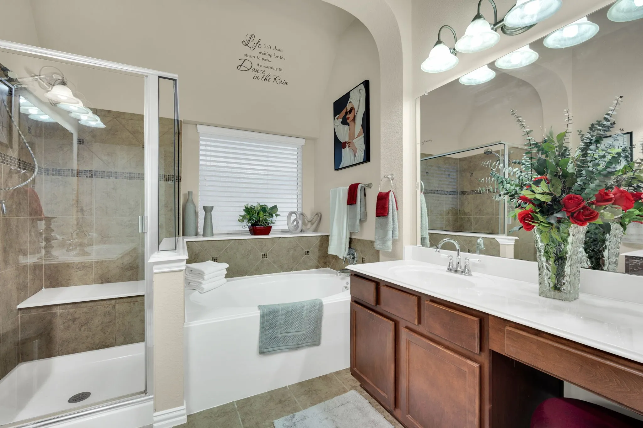 Bathroom featuring a glass-enclosed shower with tiled walls and a built-in bench, alongside a separate soaking tub with tiled surround