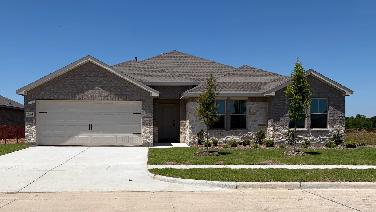 Contemporary single-story residence featuring a brick and stone exterior