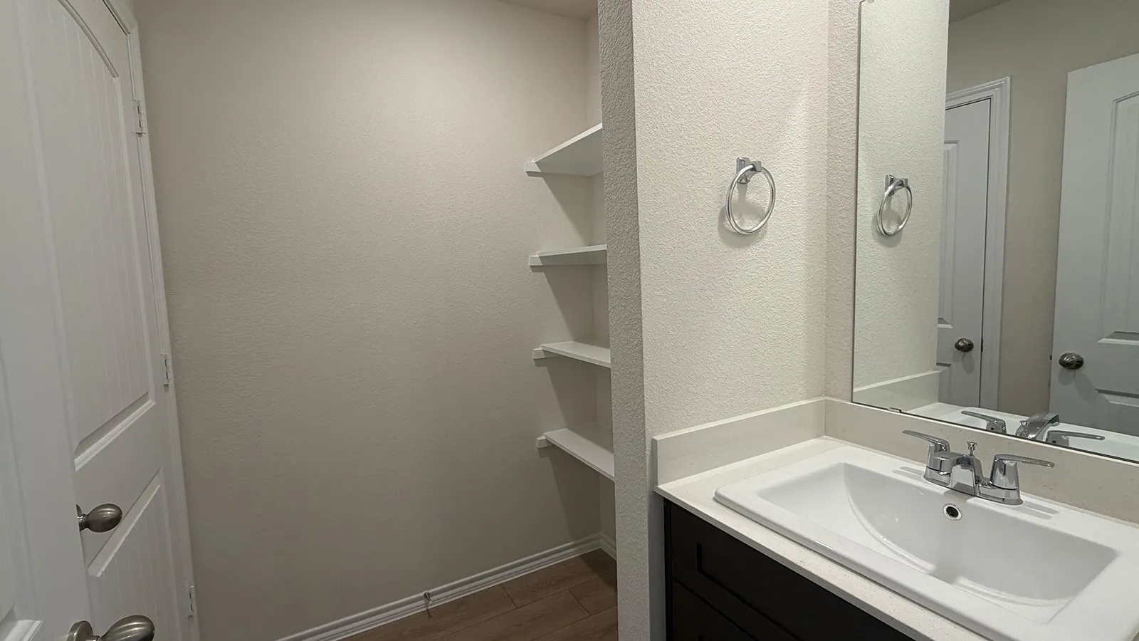 Vanity featuring a white countertop with an integrated sink, chrome faucet, and a large mirror