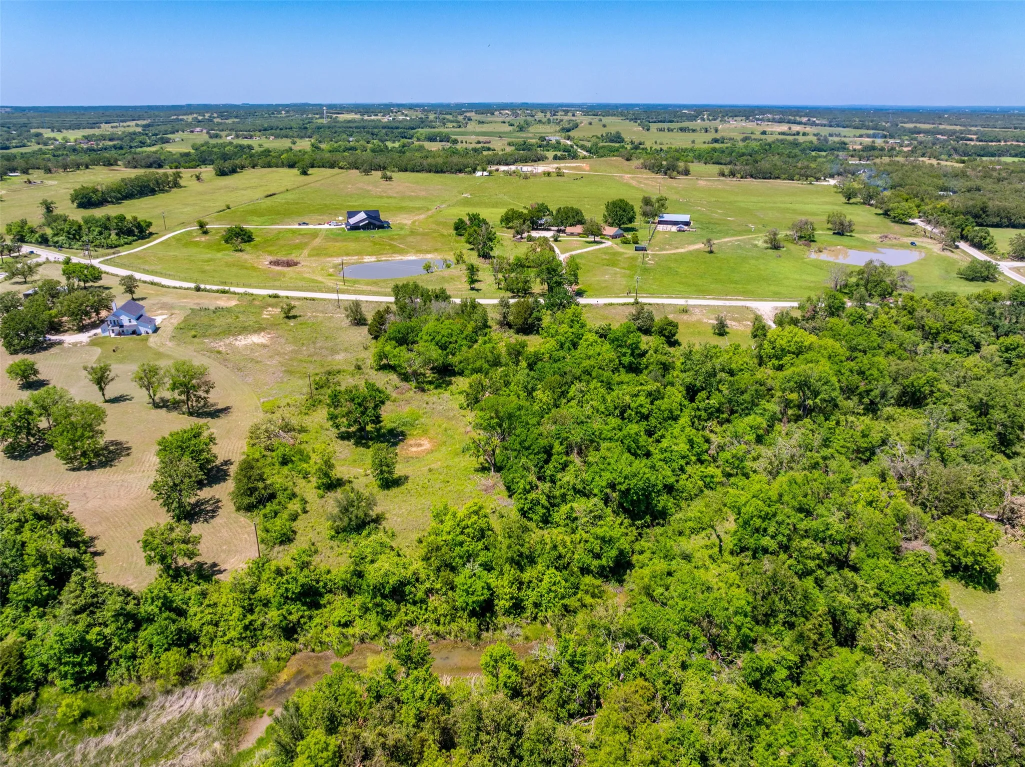 Expansive rural landscape featuring a mix of mature trees and open grassy areas