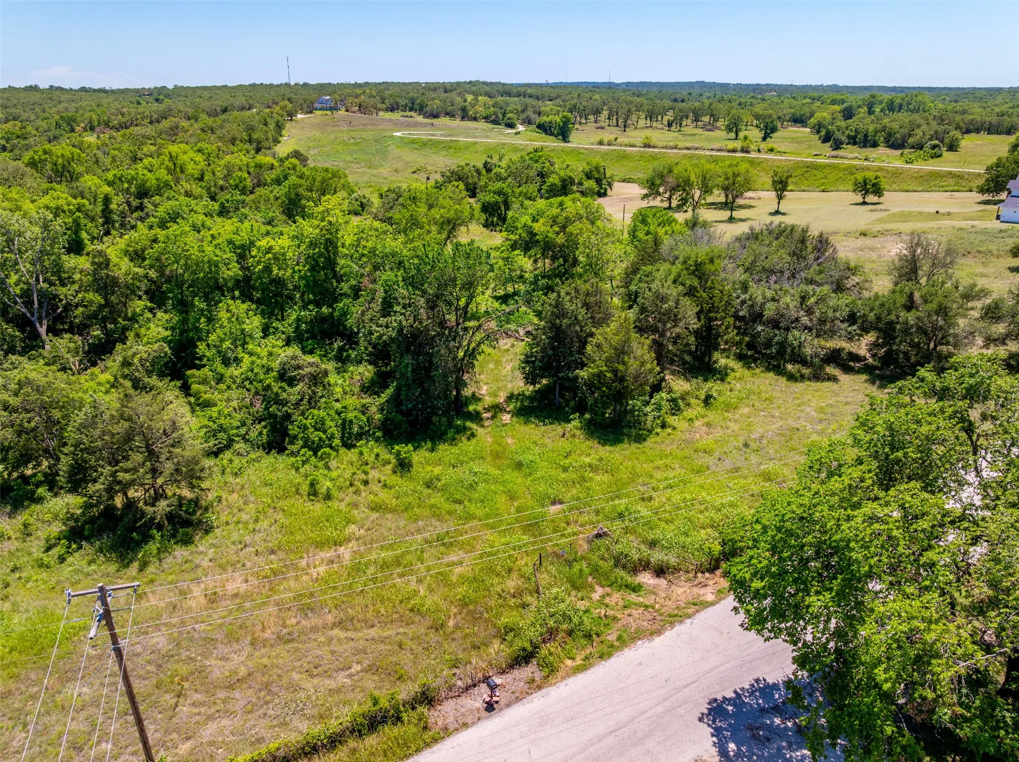 Expansive land parcel featuring a mix of mature trees and open grassy areas