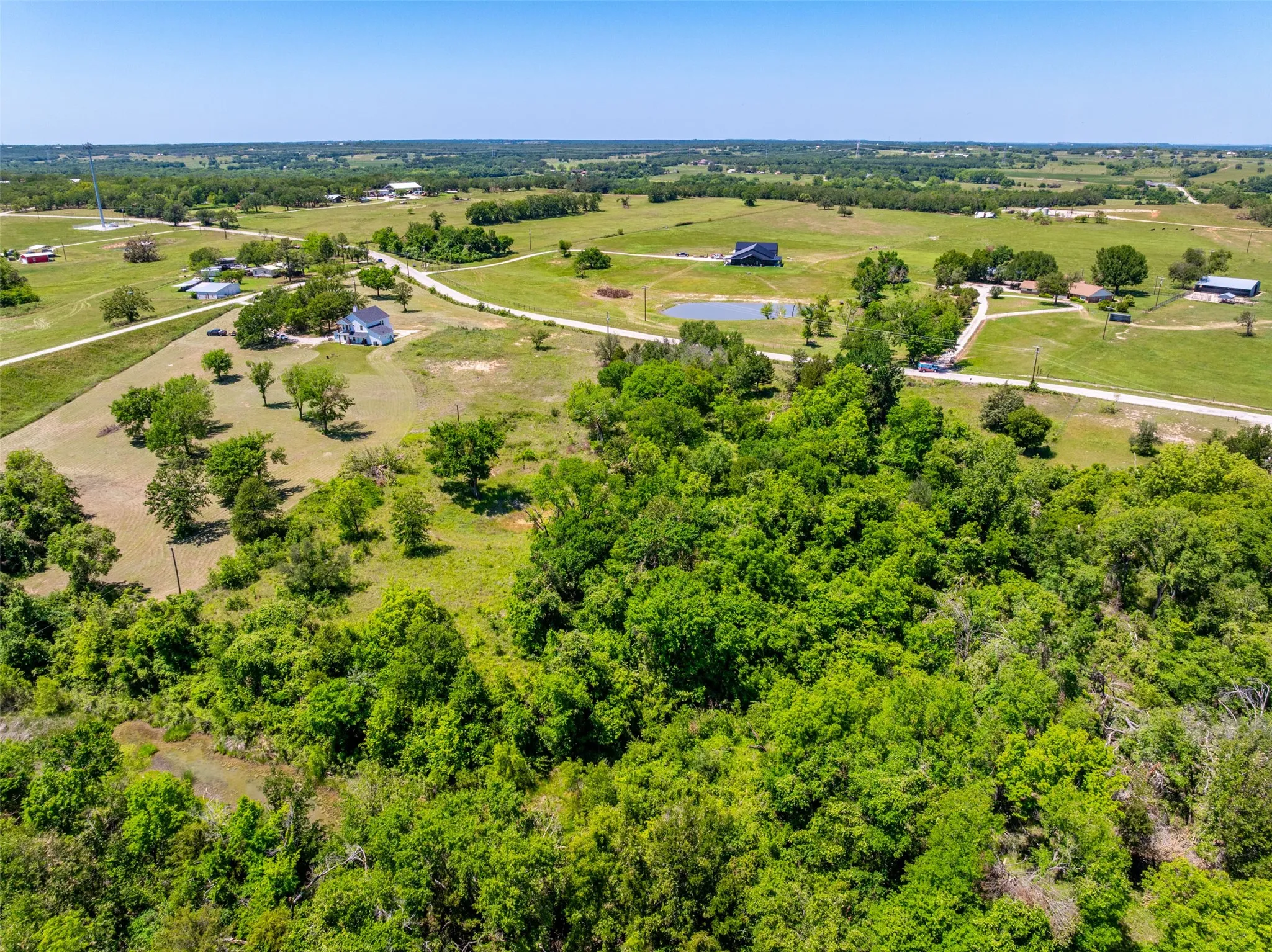 Expansive rural landscape featuring a mix of open fields and dense tree coverage