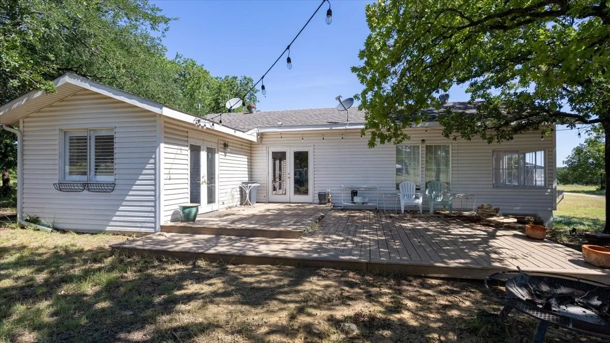 Rear exterior showcasing a spacious wood-finish deck