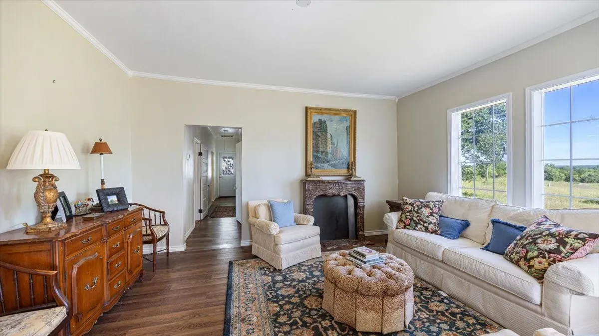 Spacious room featuring wood-finish flooring, light-colored walls, and white crown molding