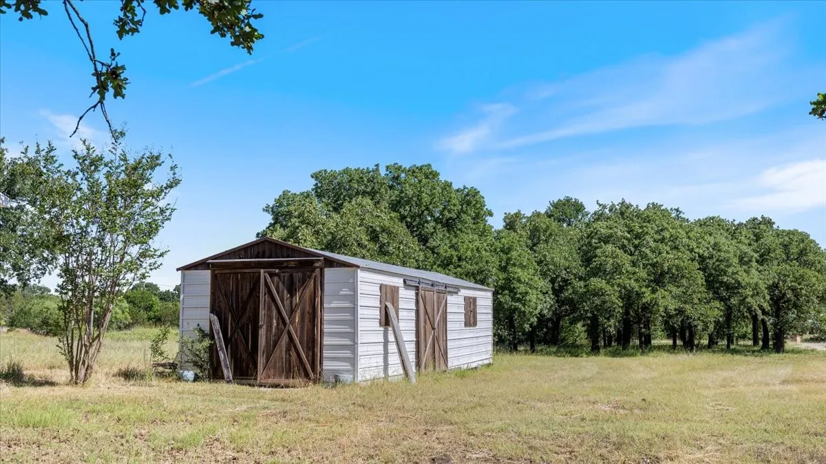 Metal utility building with a pitched roof and double wooden barn doors