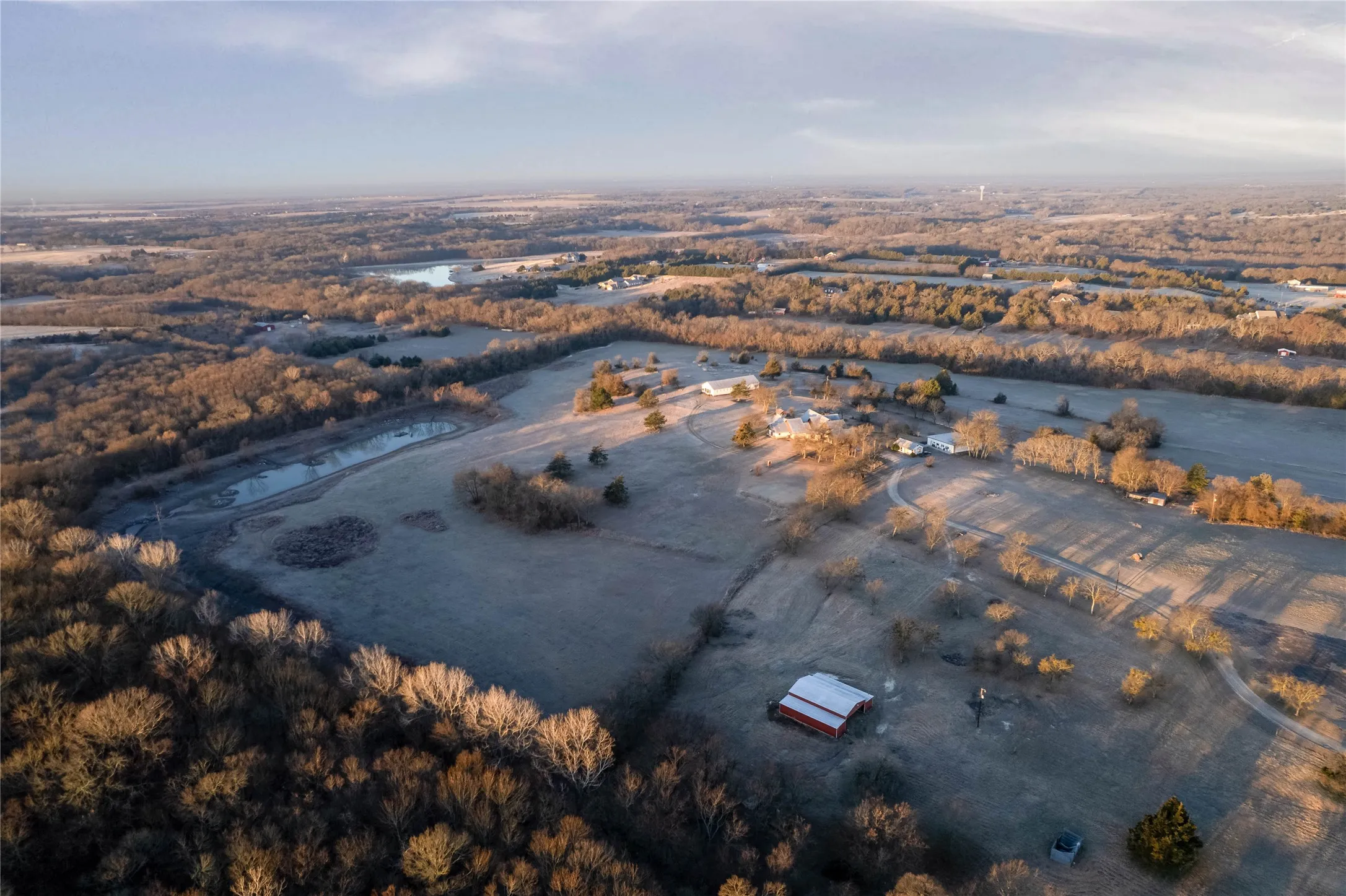 Expansive property featuring multiple structures, including a primary residence and a red barn