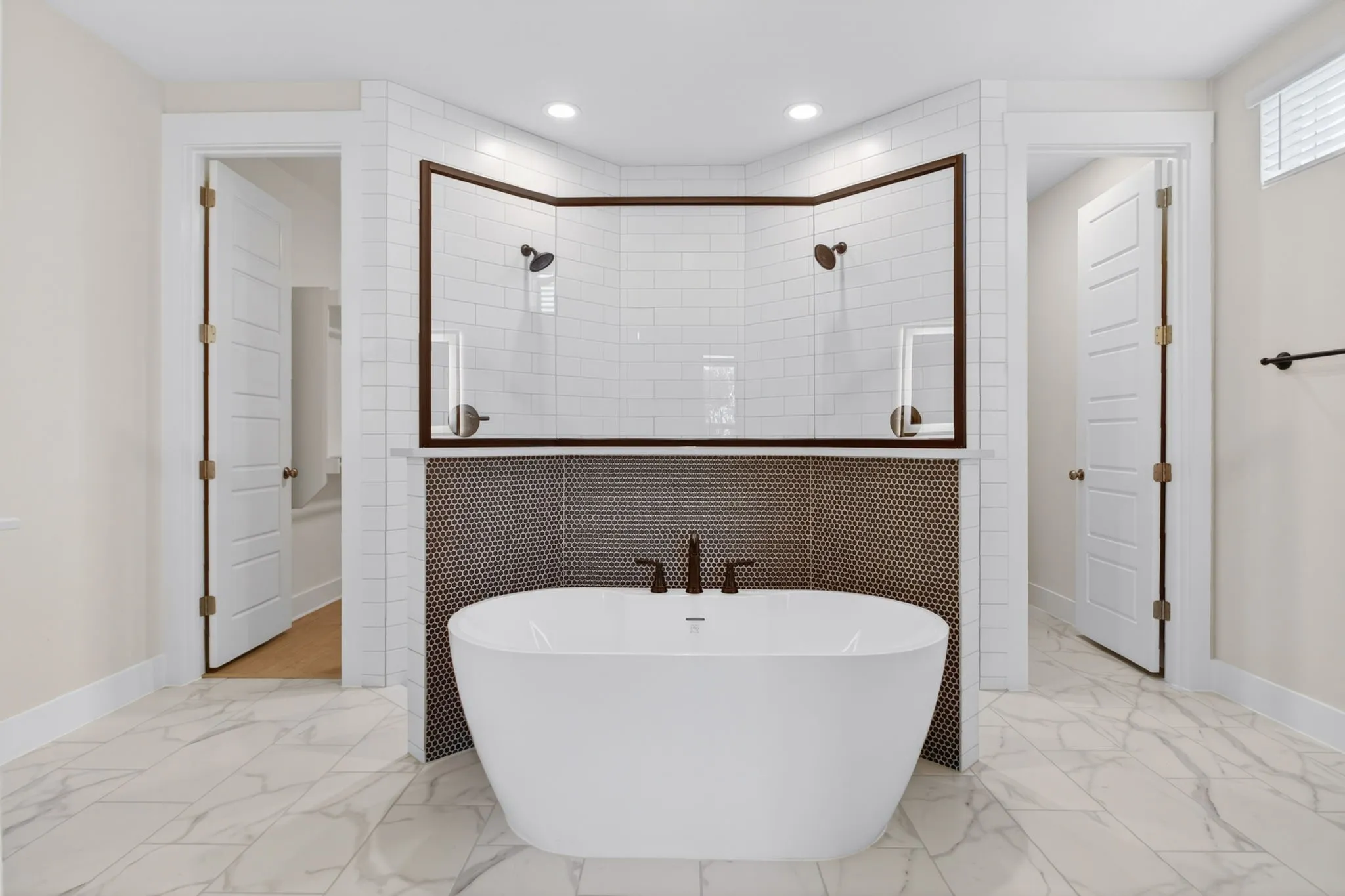 Freestanding soaking tub with dark bronze fixtures