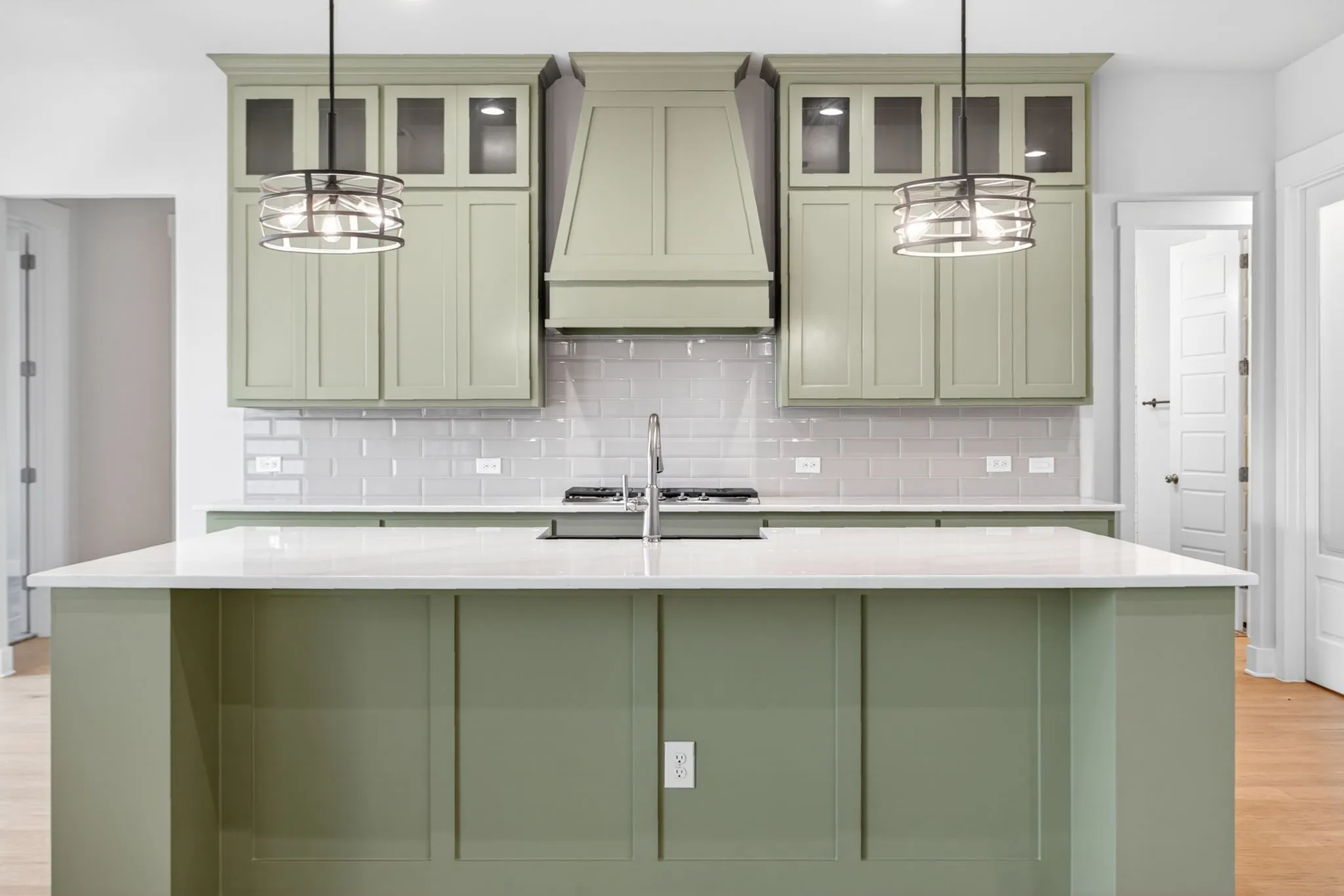 Kitchen island with a light-toned countertop and paneled base, complemented by matching cabinetry