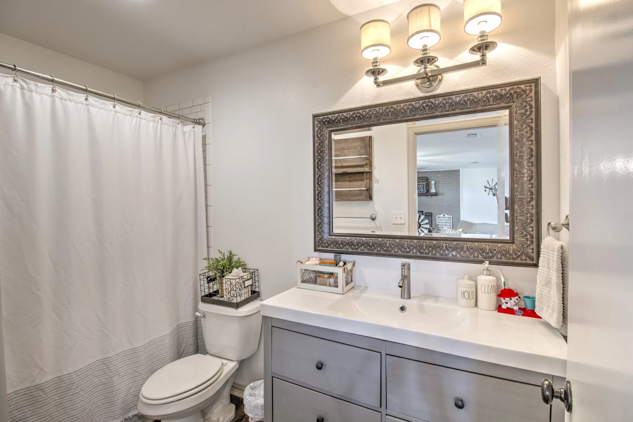 Second bathroom with vanity sink and step in tub/shower.