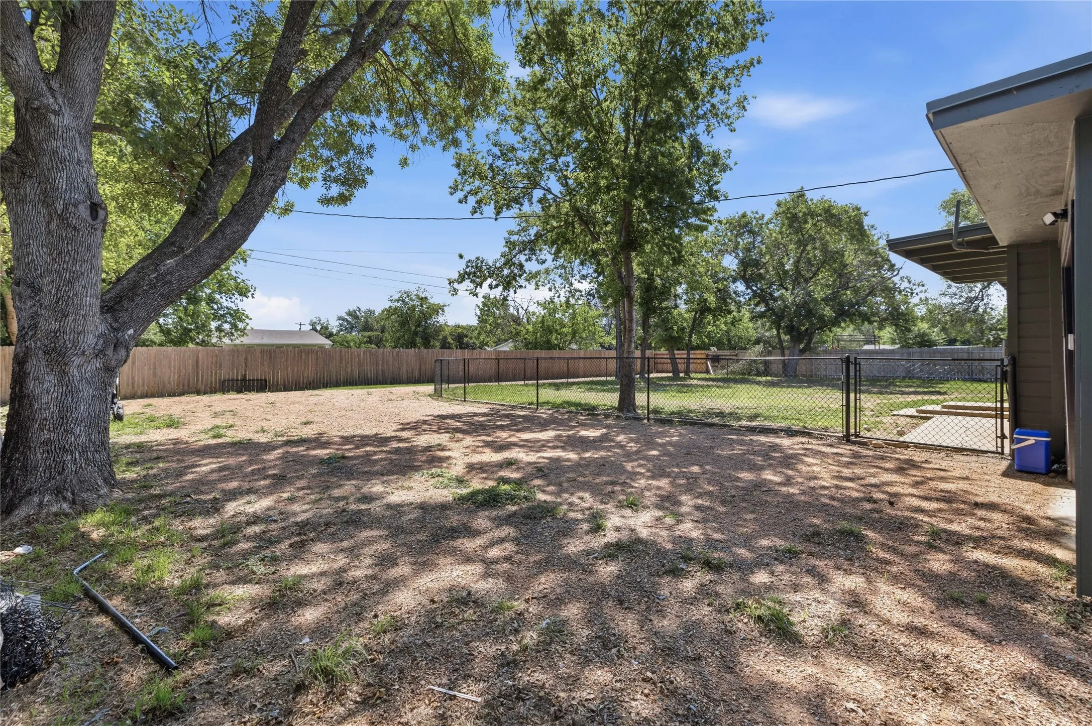 Drive way has a fence on both sides to keep pets in backyard