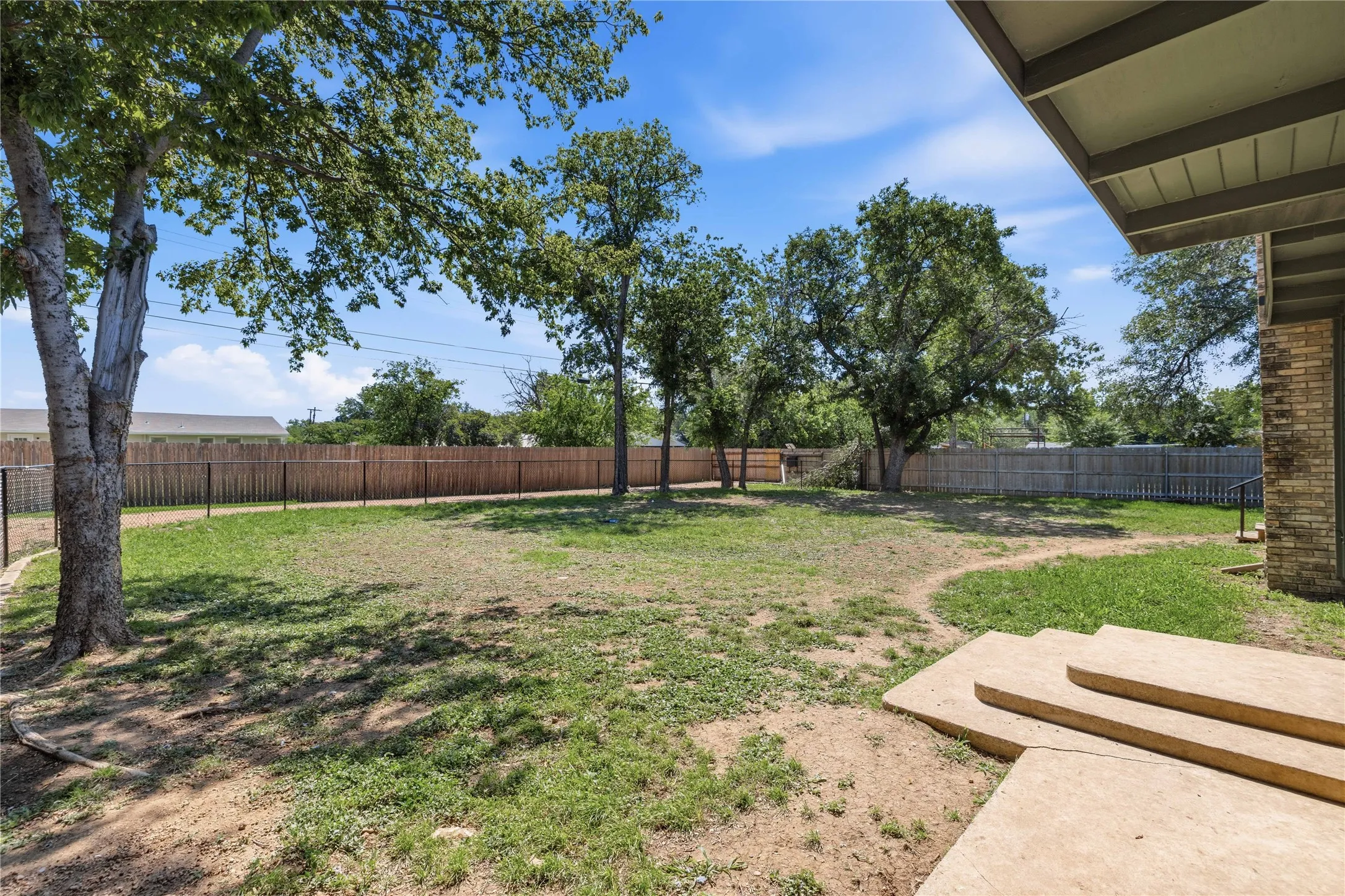 Backyard has a black fence inside the perimeter fence.