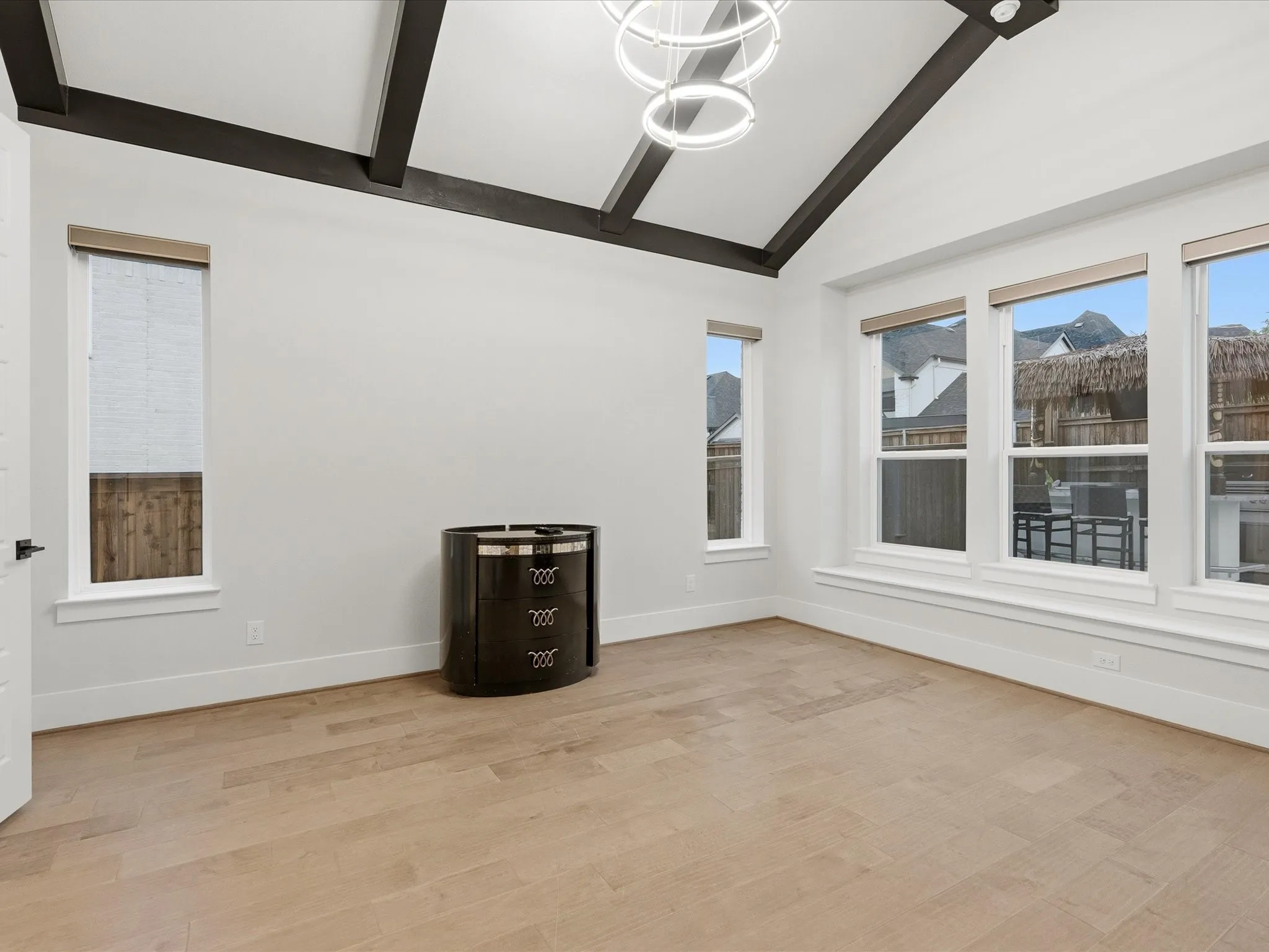 Vaulted ceiling with exposed beams and a contemporary chandelier
