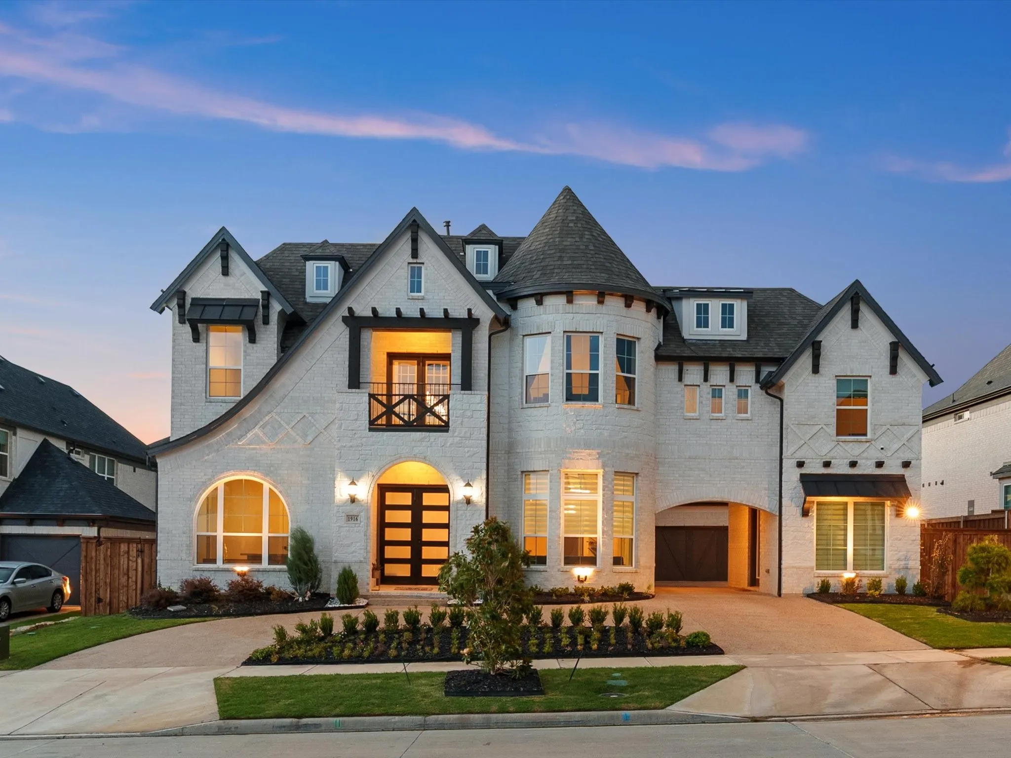 Stately residence featuring a prominent turret, light brick exterior, and dark trim accents