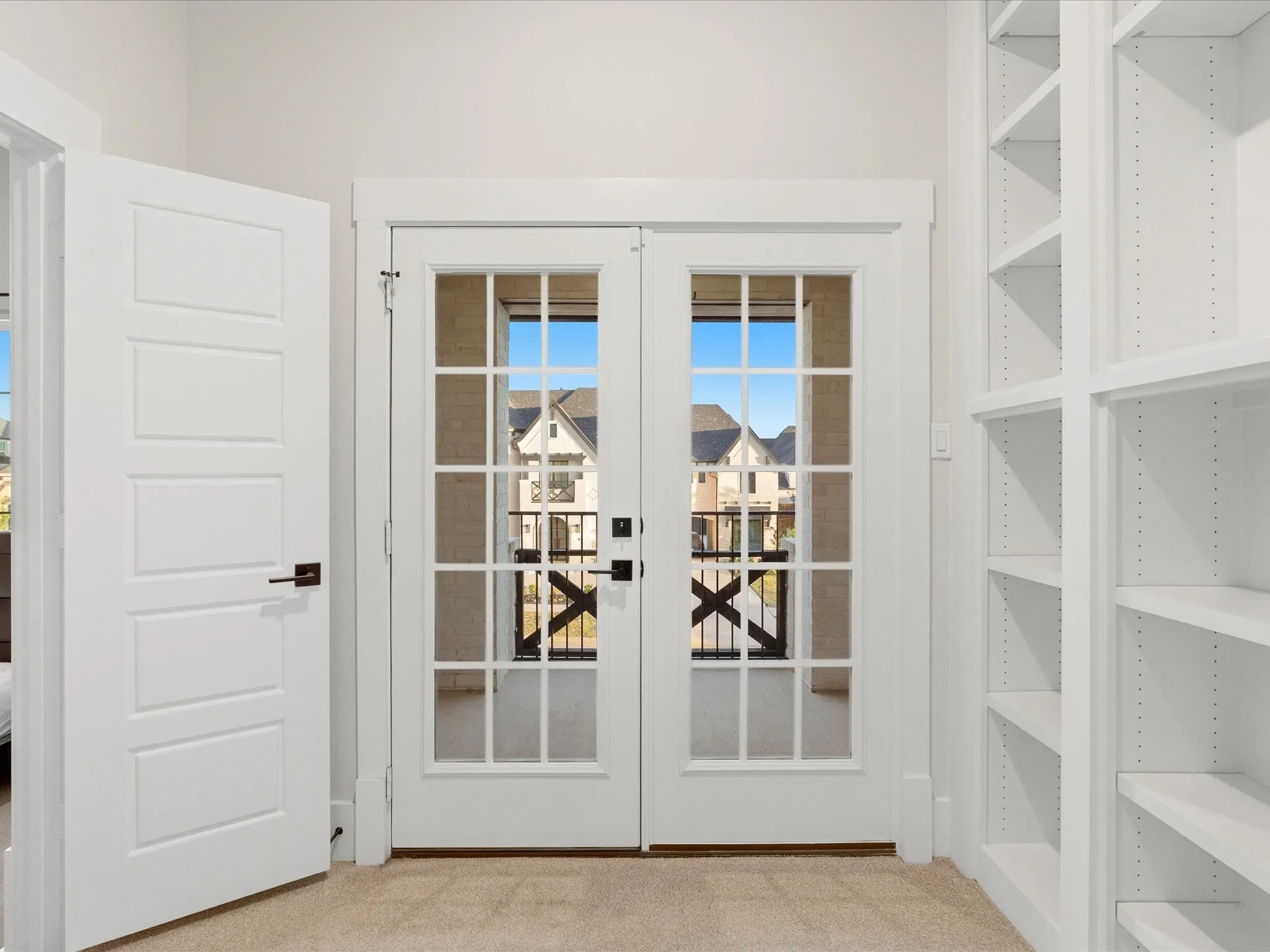 Double French doors with divided lites open to an exterior balcony