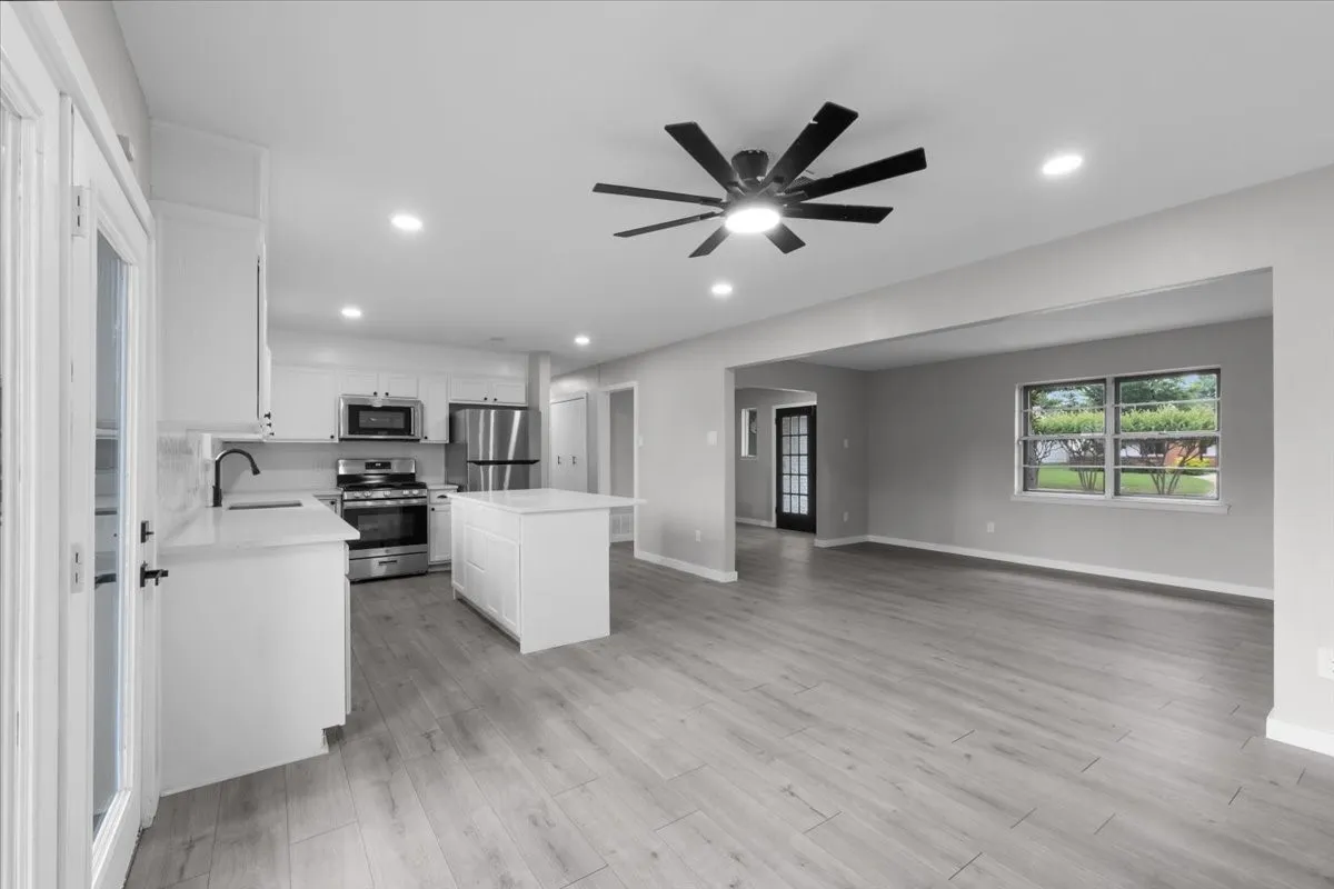 Open-concept living space featuring wood-finish flooring and recessed lighting