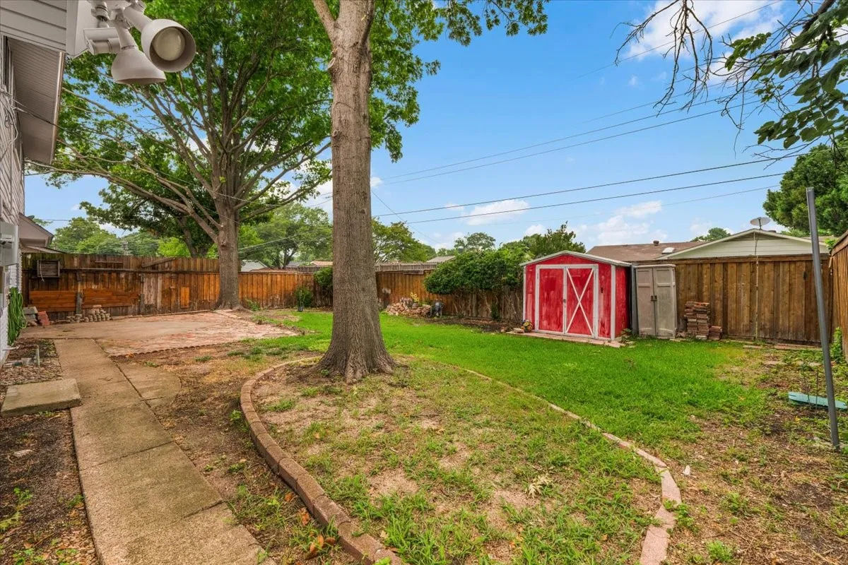 Expansive outdoor space featuring a concrete paver walkway, a brick patio area, and a separate grassy section