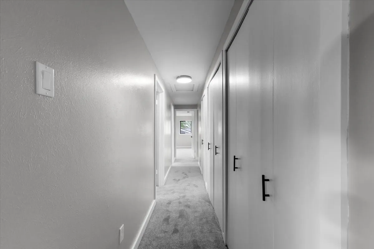 Hallway featuring light-toned walls, recessed lighting, and a neutral carpeted floor
