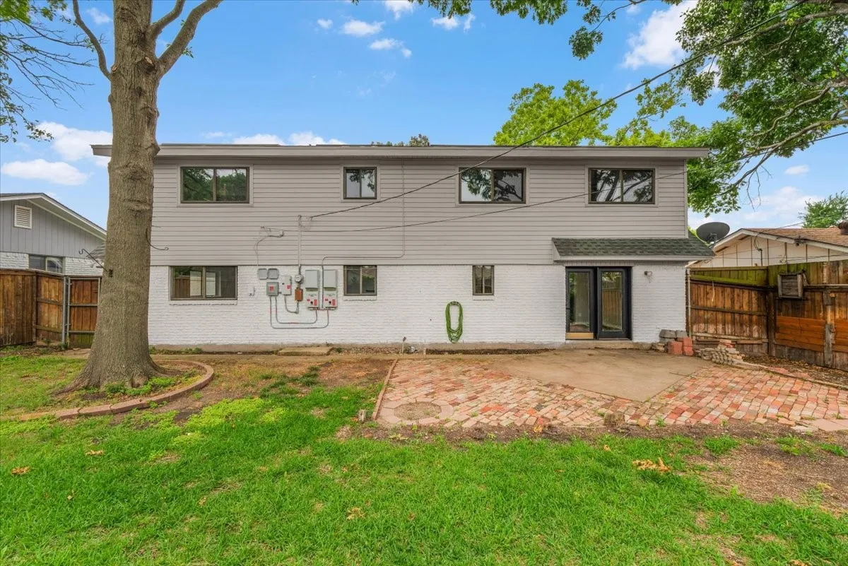 Rear exterior featuring white painted brick and horizontal siding