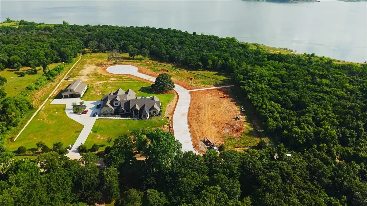 Expansive property featuring a large residence with a multi-gabled roofline and an extensive paved driveway